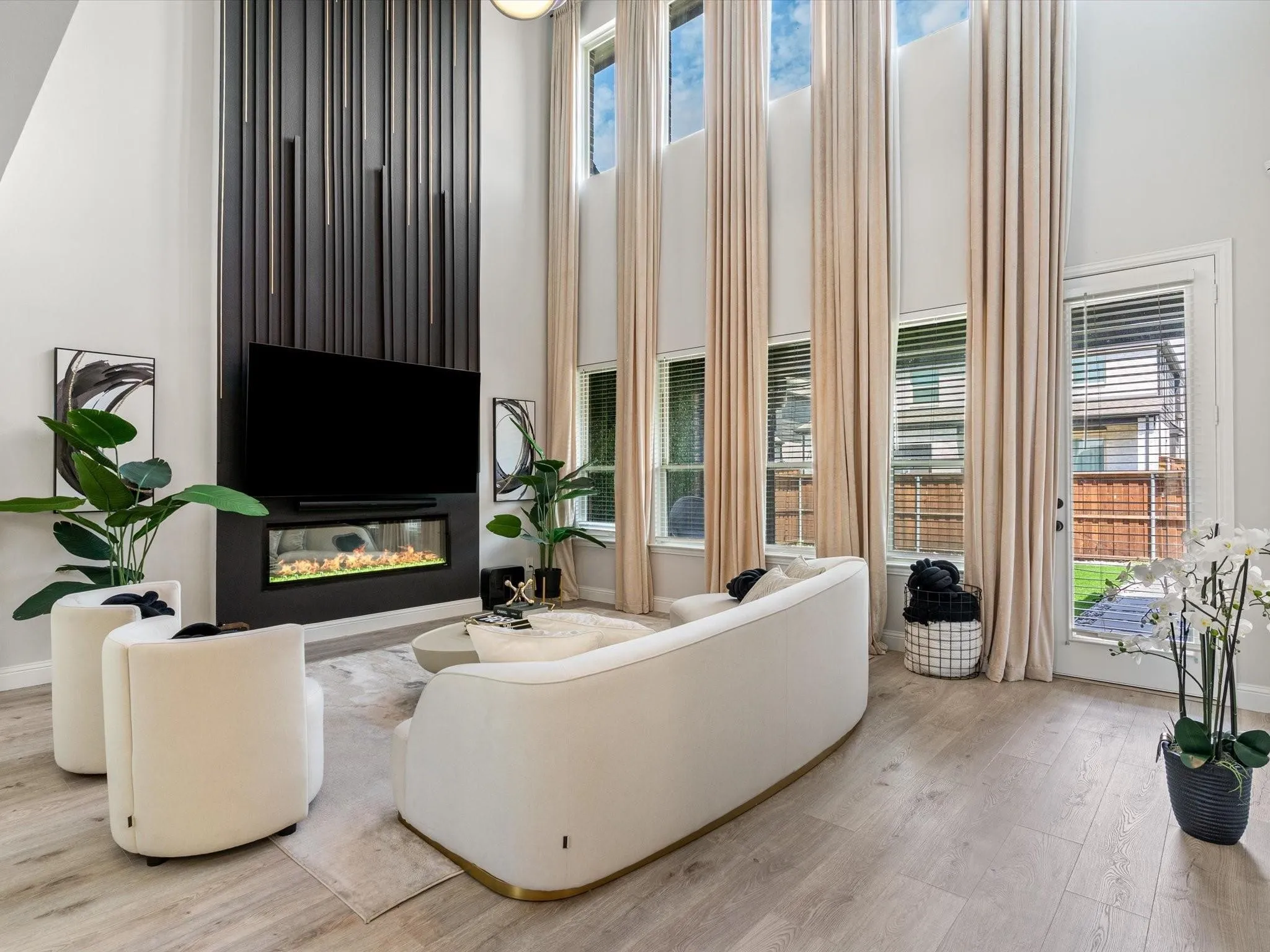 Two-story living area featuring a prominent dark-paneled accent wall with a built-in linear fireplace