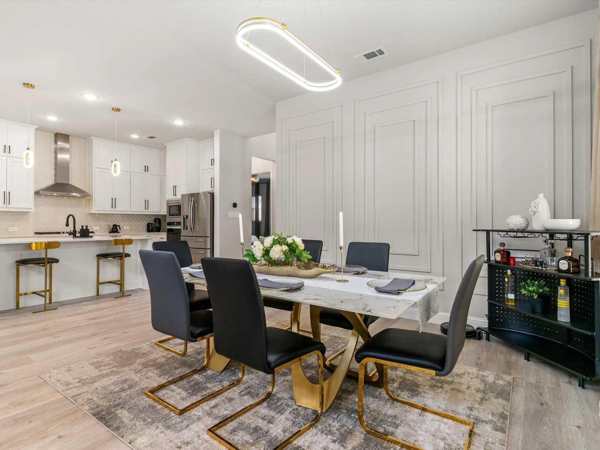 Expansive dining area featuring a modern rectangular chandelier and wall paneling
