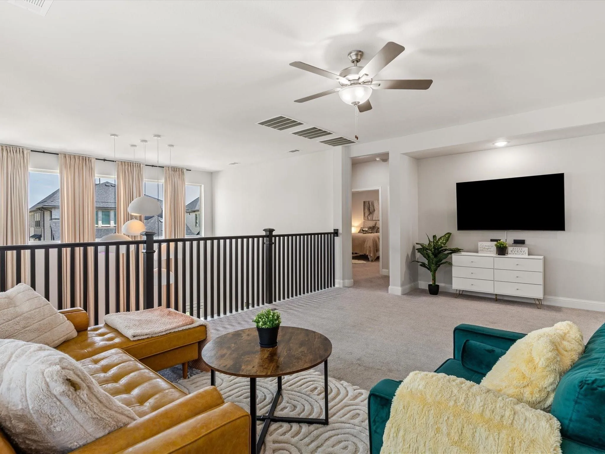 Expansive loft space featuring light gray carpeting, a contemporary ceiling fan, and recessed lighting