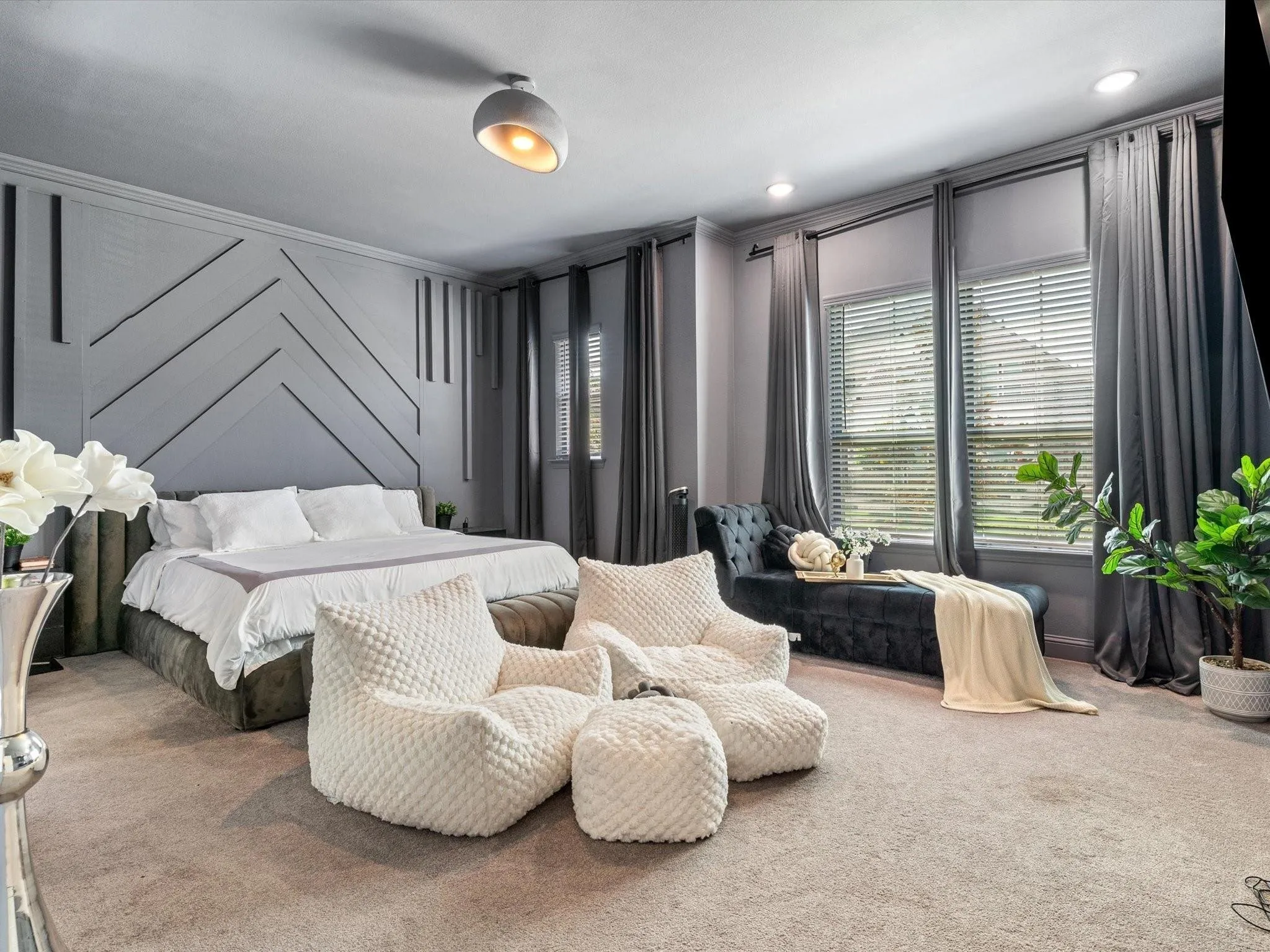 Spacious room featuring a decorative accent wall, two large windows with blinds and drapery, and recessed lighting