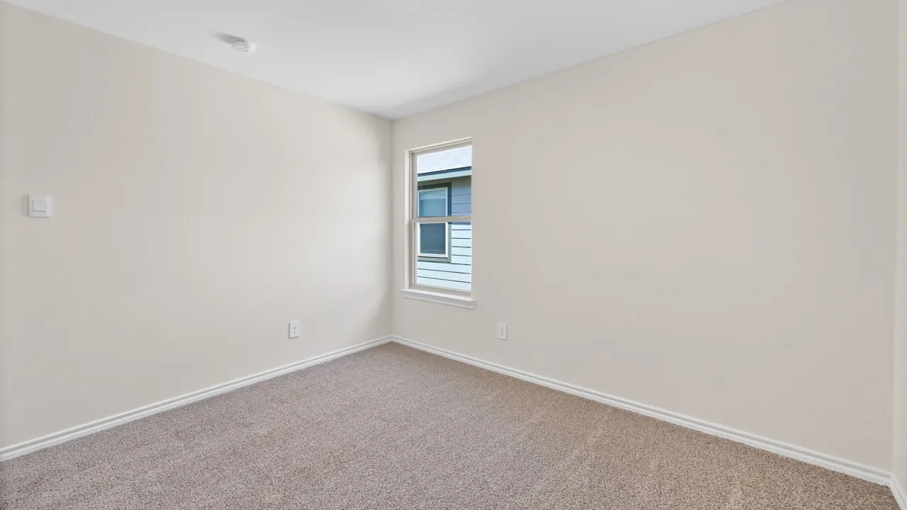 Room featuring light neutral painted walls, light brown carpet flooring, and white baseboards