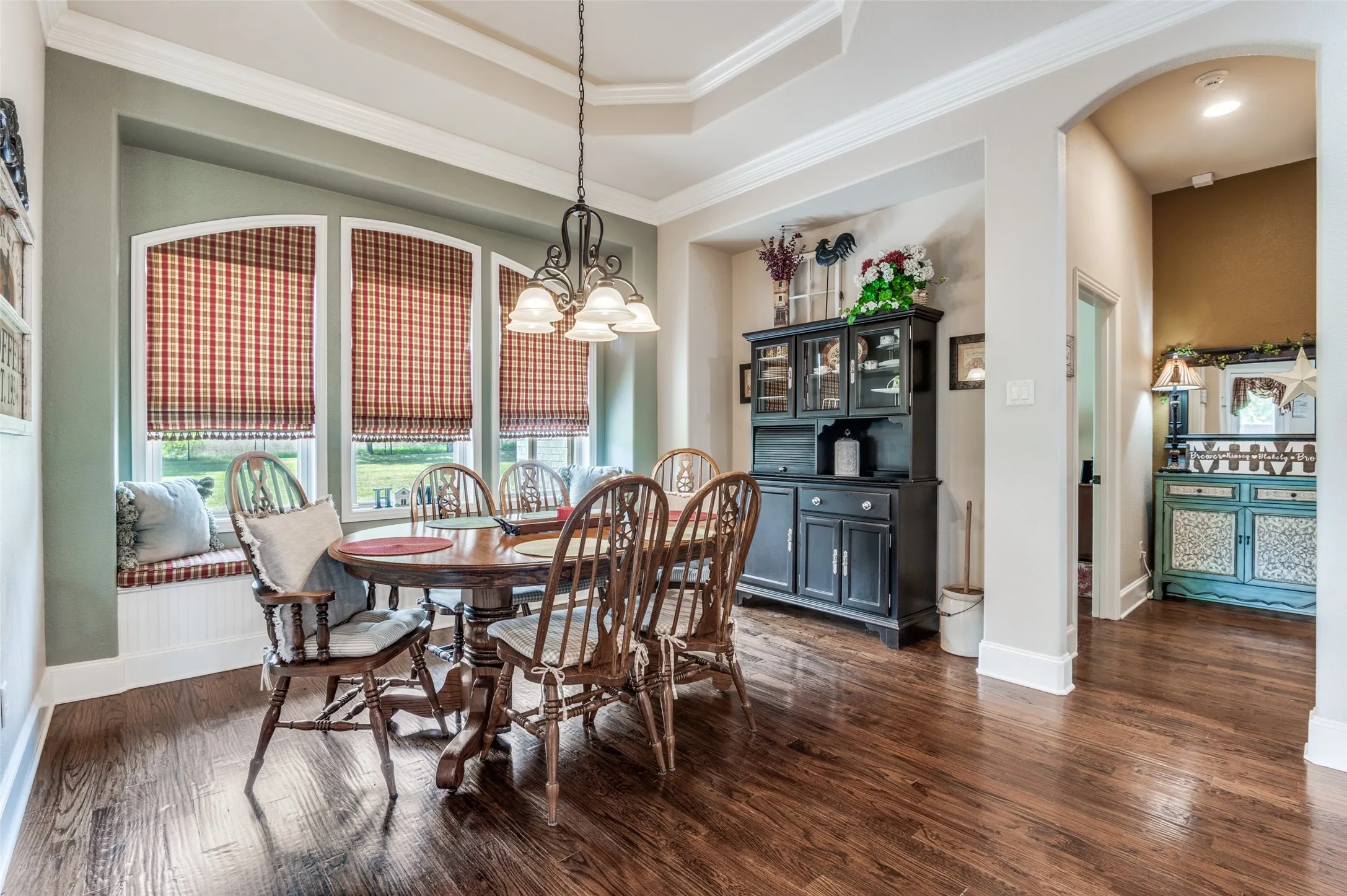 Custom window treatments, window seat, door to patio, hall to primary suite and laundry.