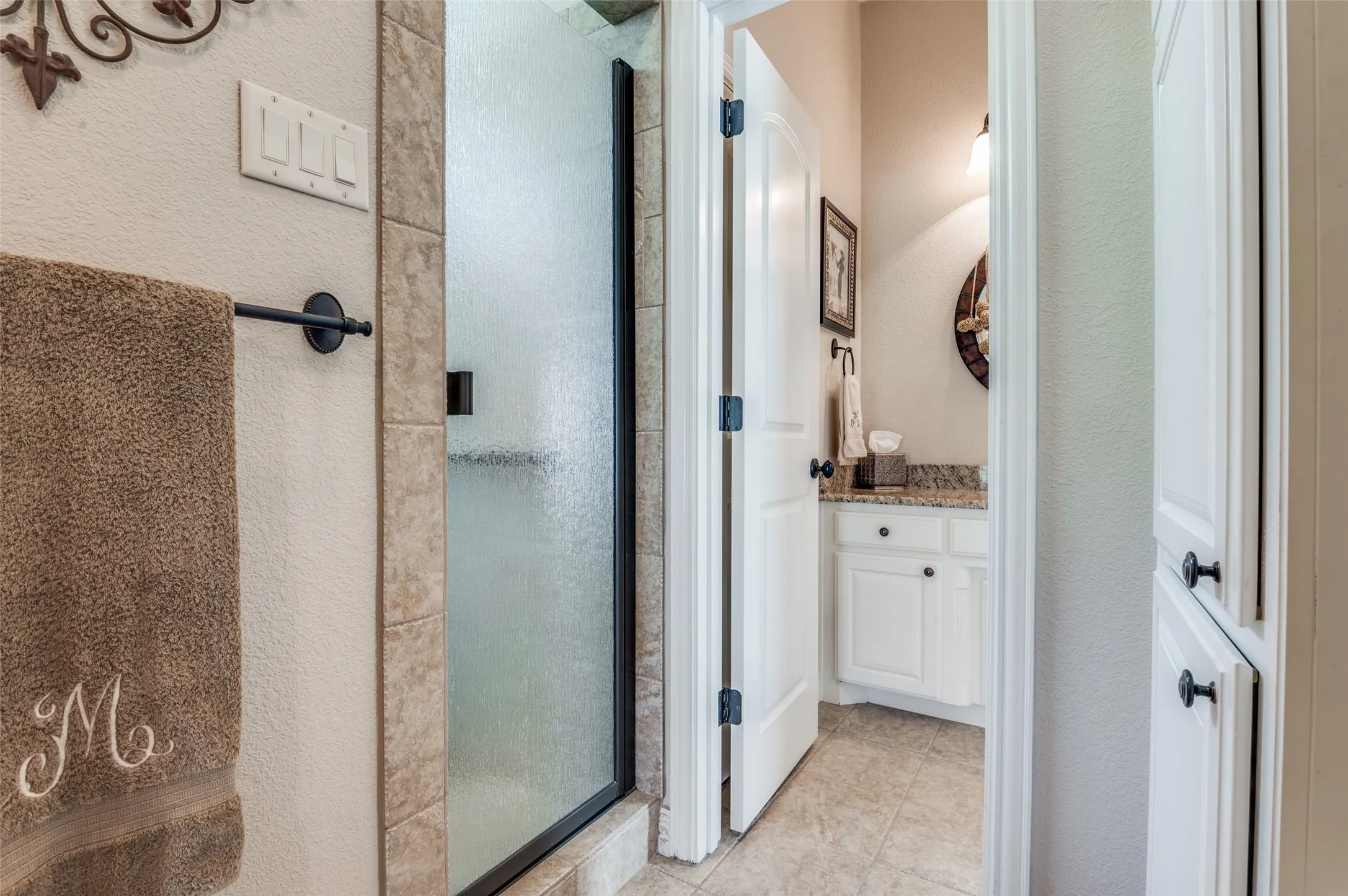 This bathroom features a large walk in shower, linen storage and potty!