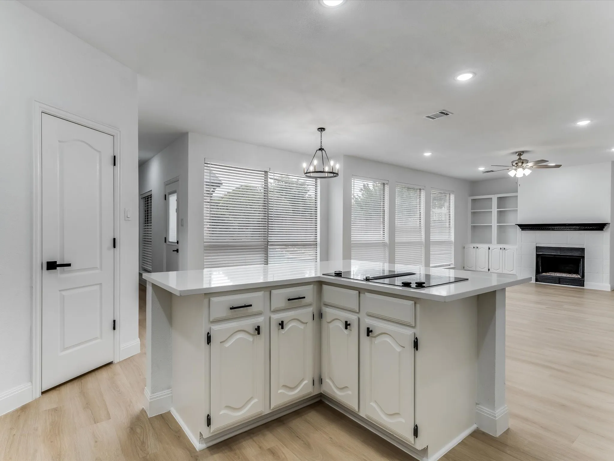 Kitchen island featuring a built-in cooktop and light-toned countertop