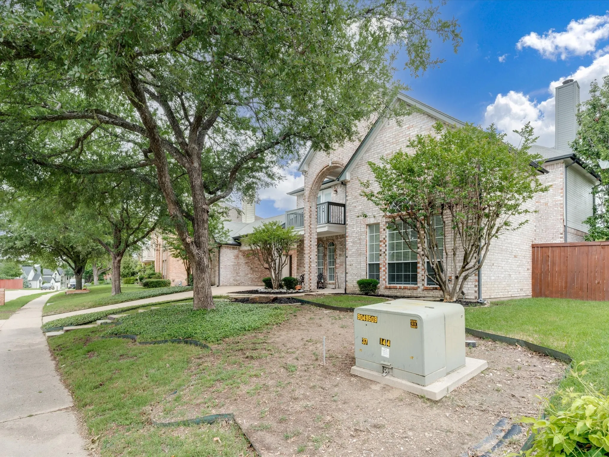 Brick facade residence featuring a prominent arched entrance