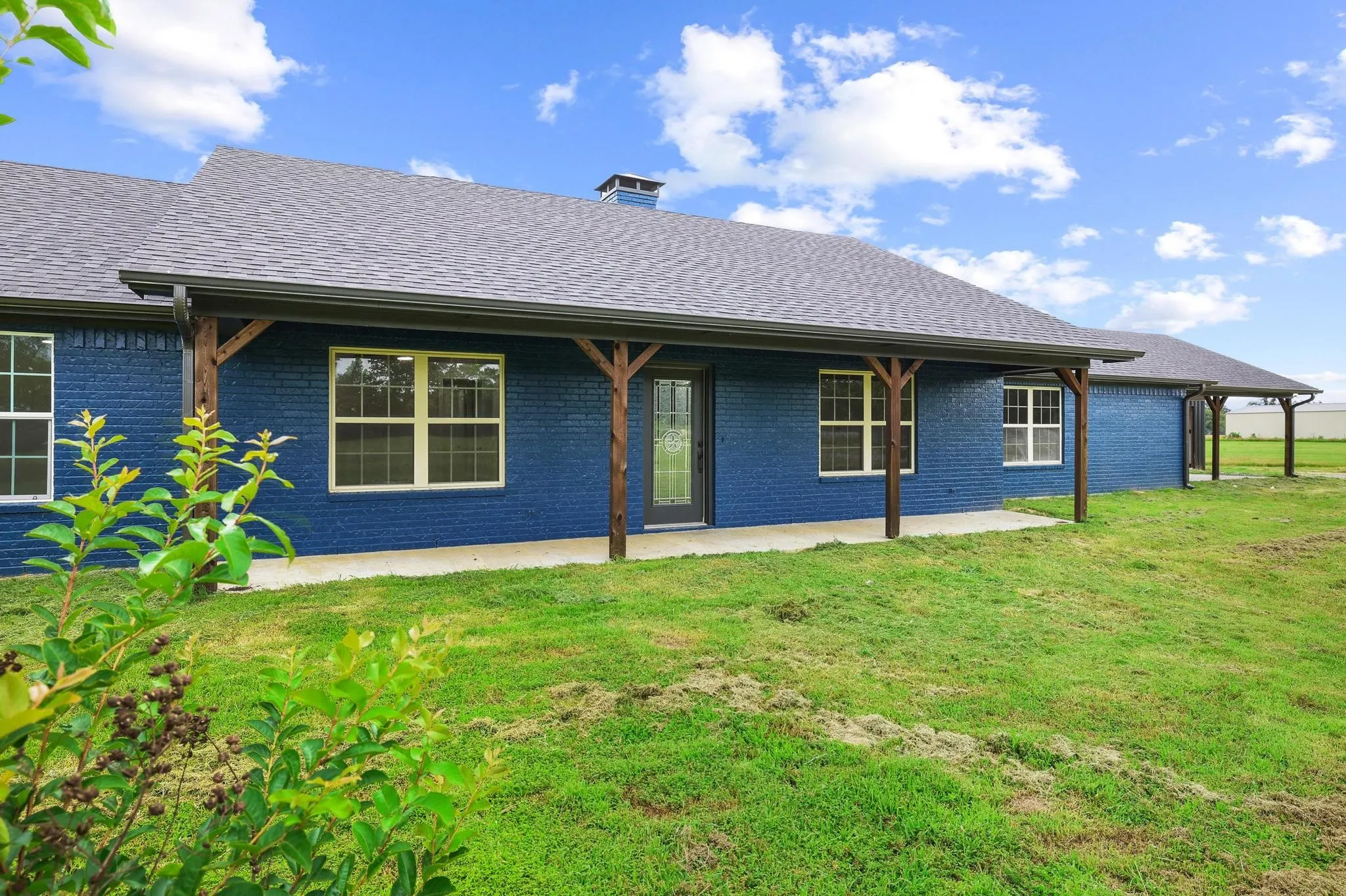 Deep blue brick exterior with a dark shingle roof