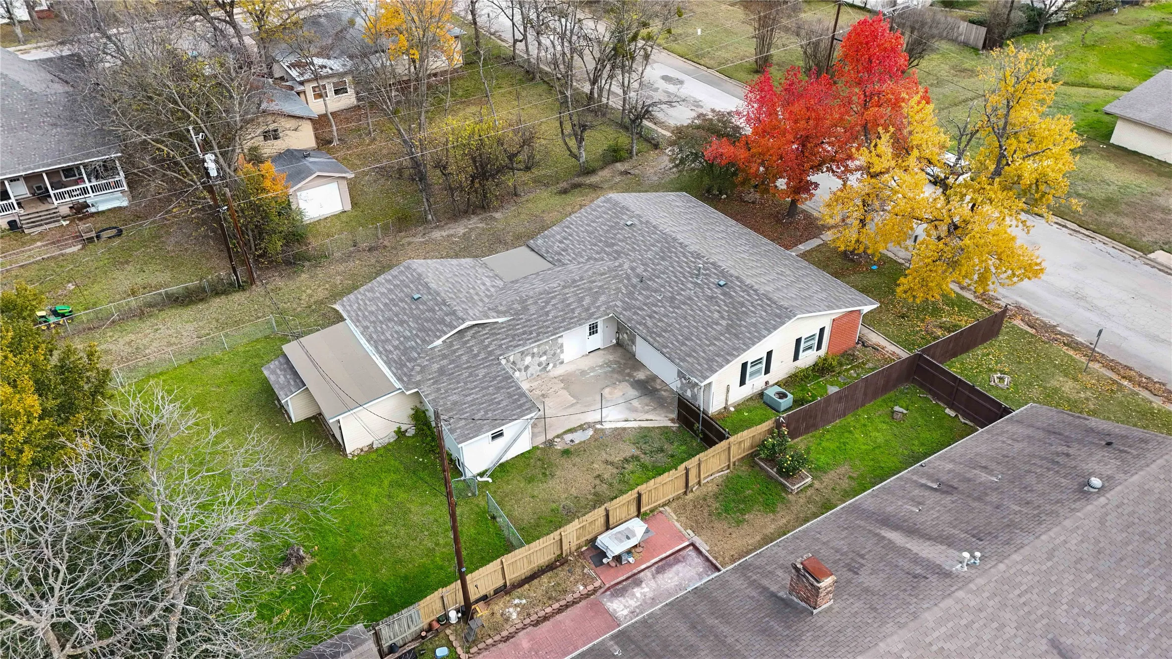 Single-story residence featuring a shingled roof and a stone facade accent