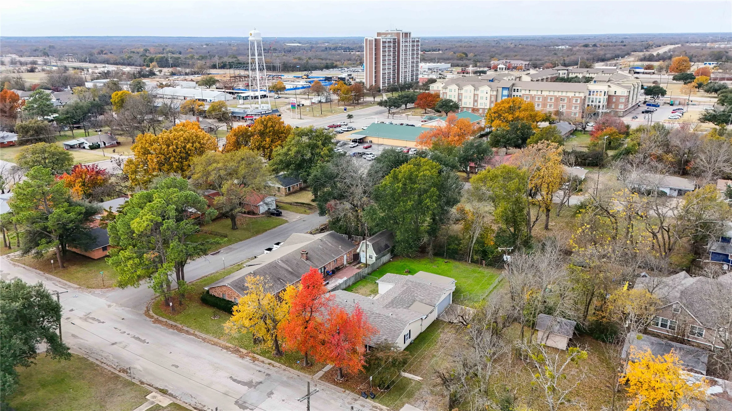 Aerial perspective showcasing an established neighborhood with a mix of residential properties and mature trees