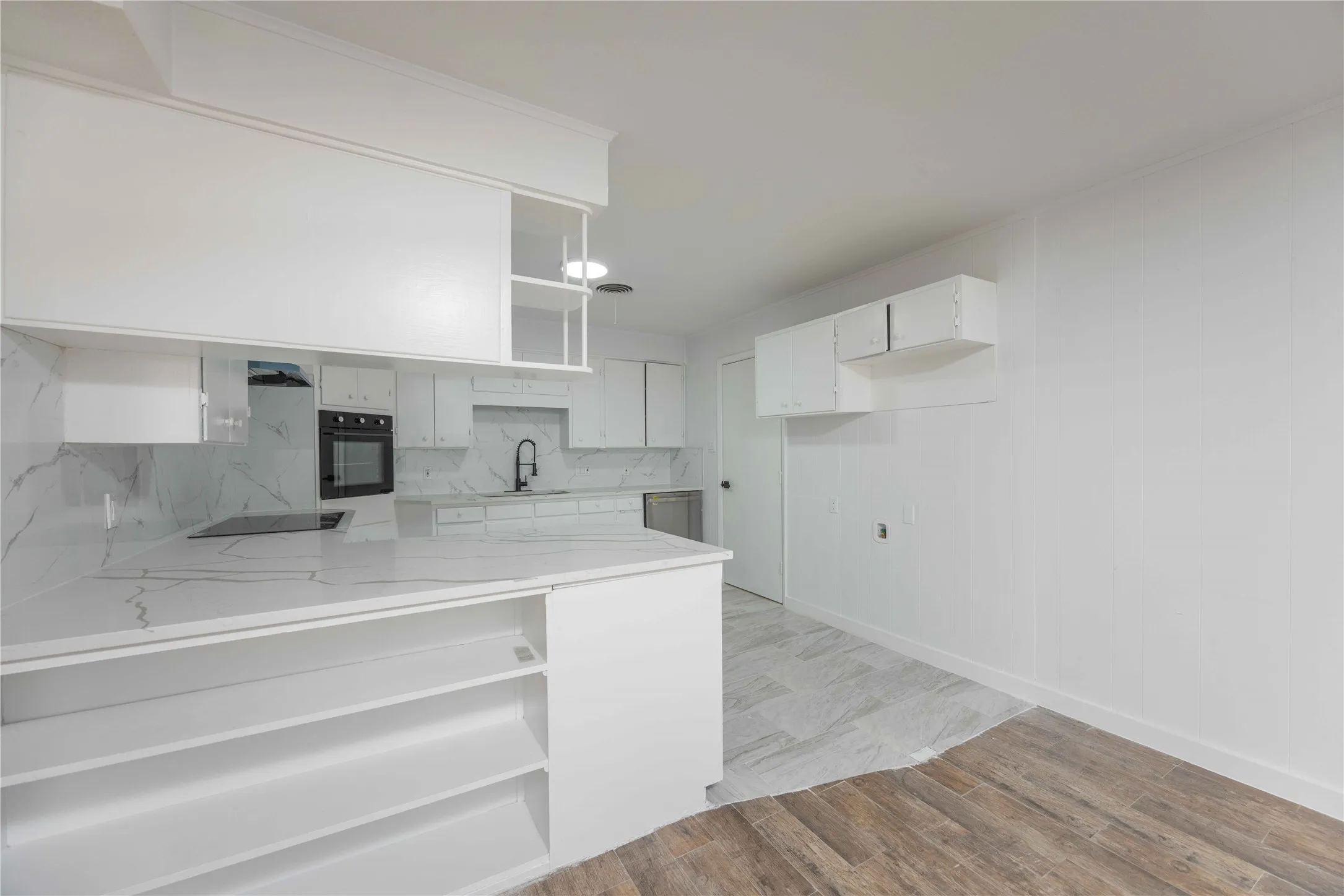 Contemporary kitchen featuring white cabinetry and countertops with subtle grey veining