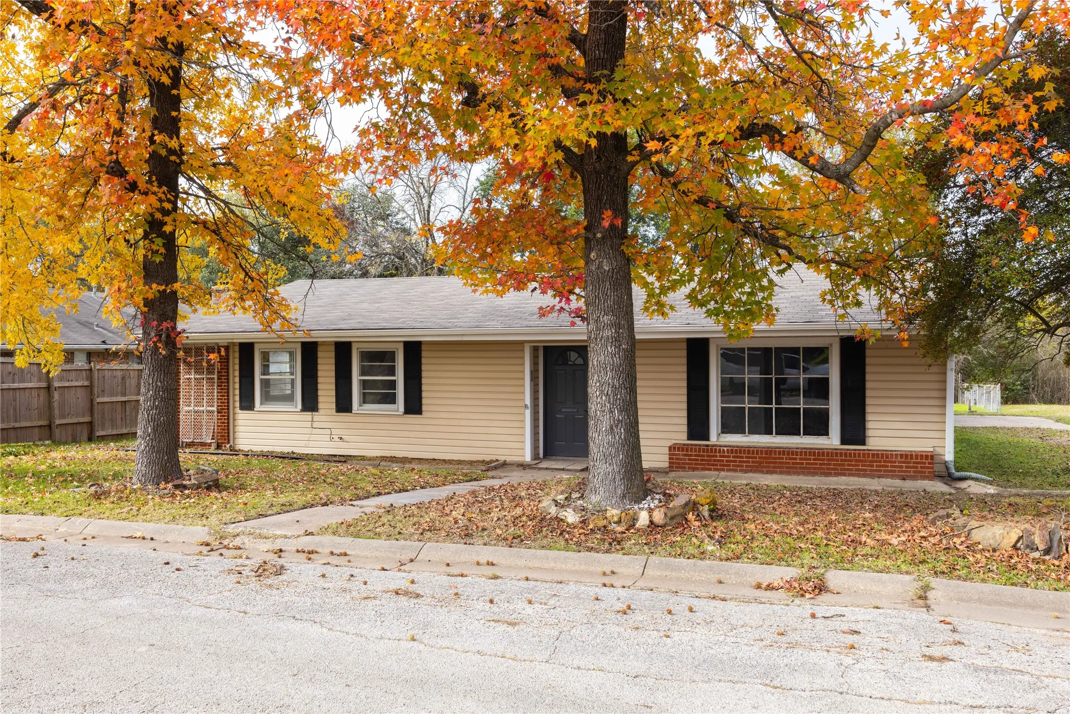 Single-story residence featuring light-colored siding and a dark entry door