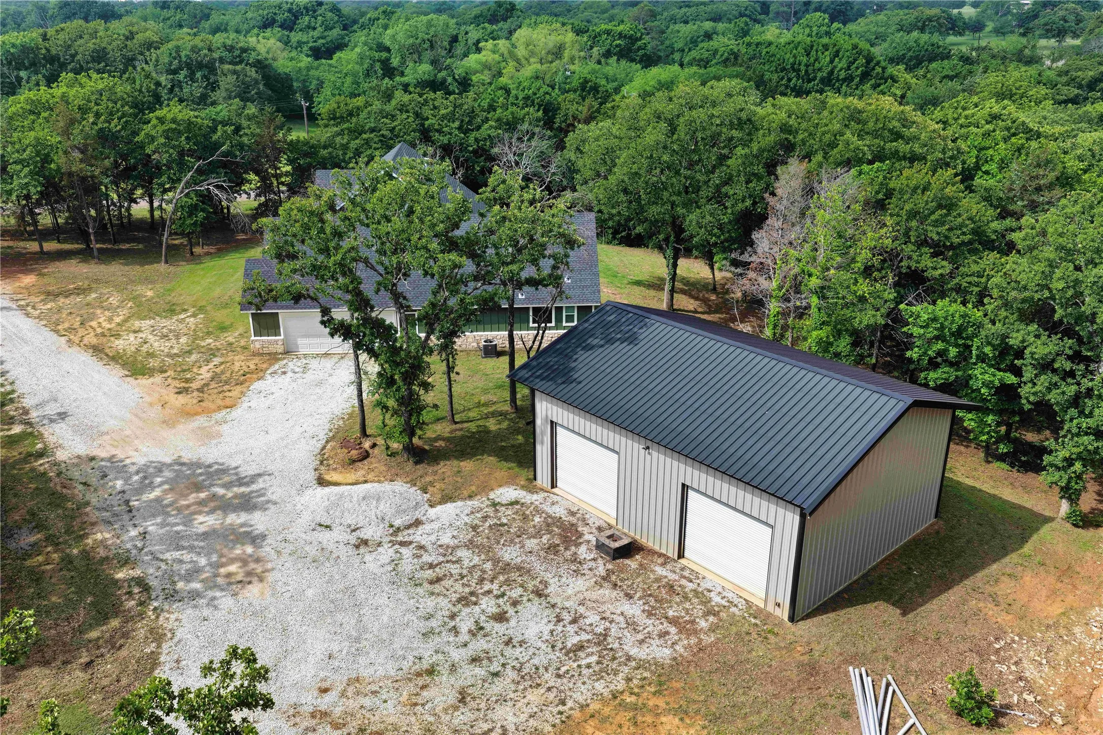 Two-bay metal garage with a dark metal roof and light-colored siding