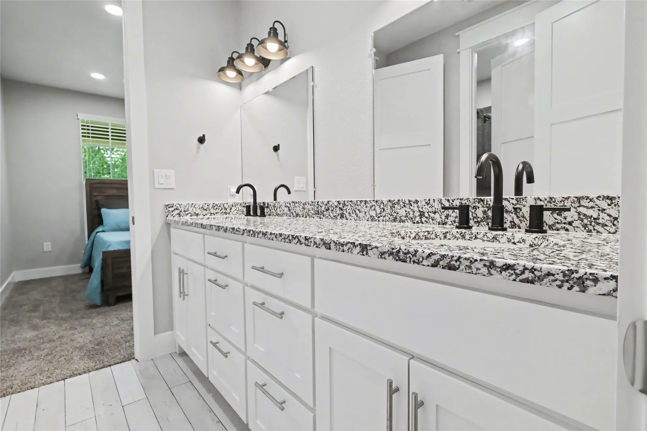Dual vanity with white cabinetry and granite-patterned countertops