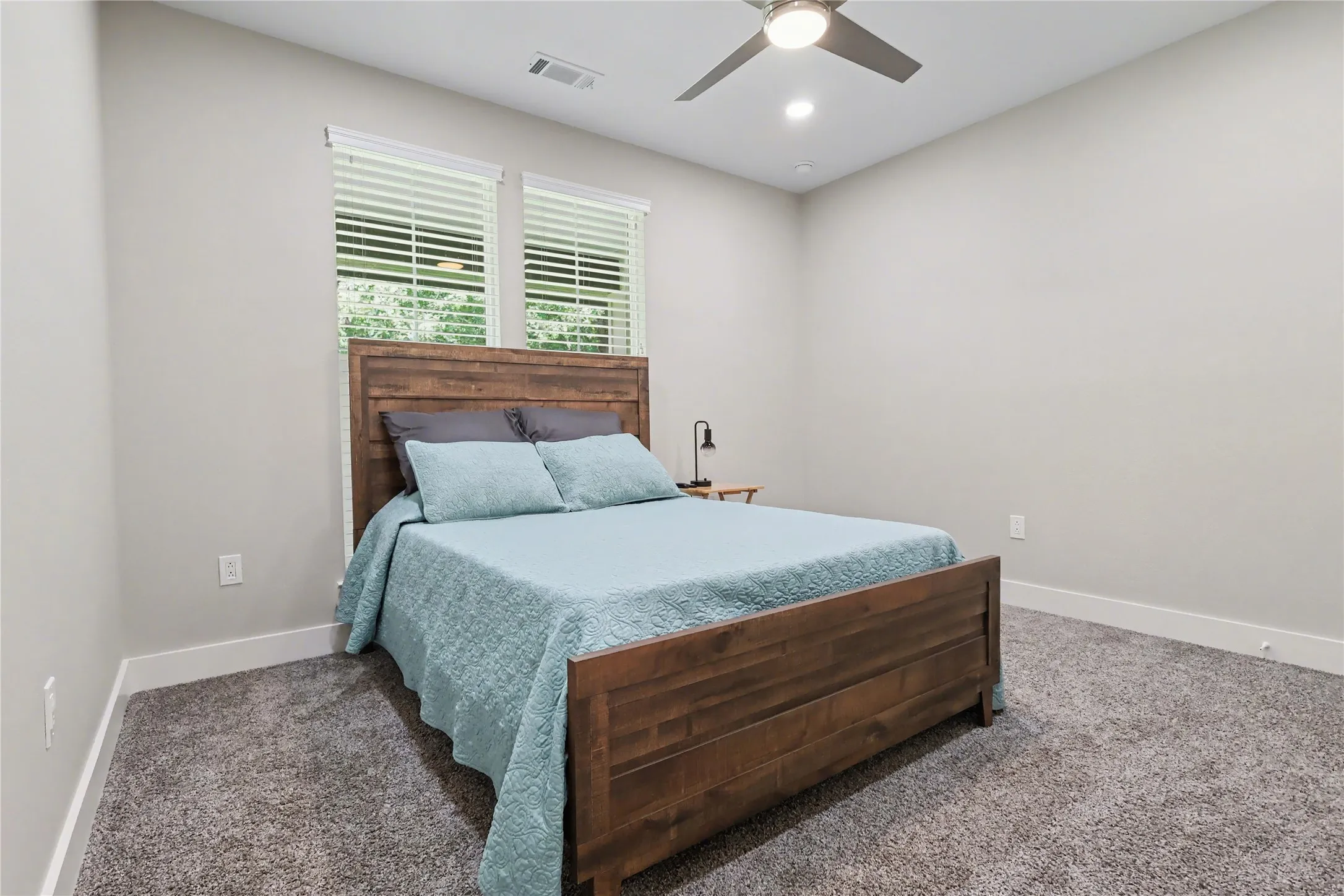 Room featuring two large windows with blinds, recessed lighting, and a ceiling fan