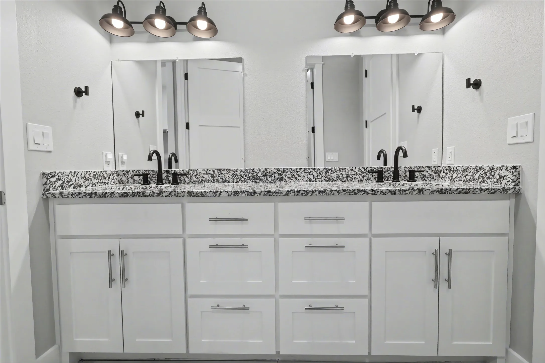Double vanity with white cabinetry and brushed nickel hardware