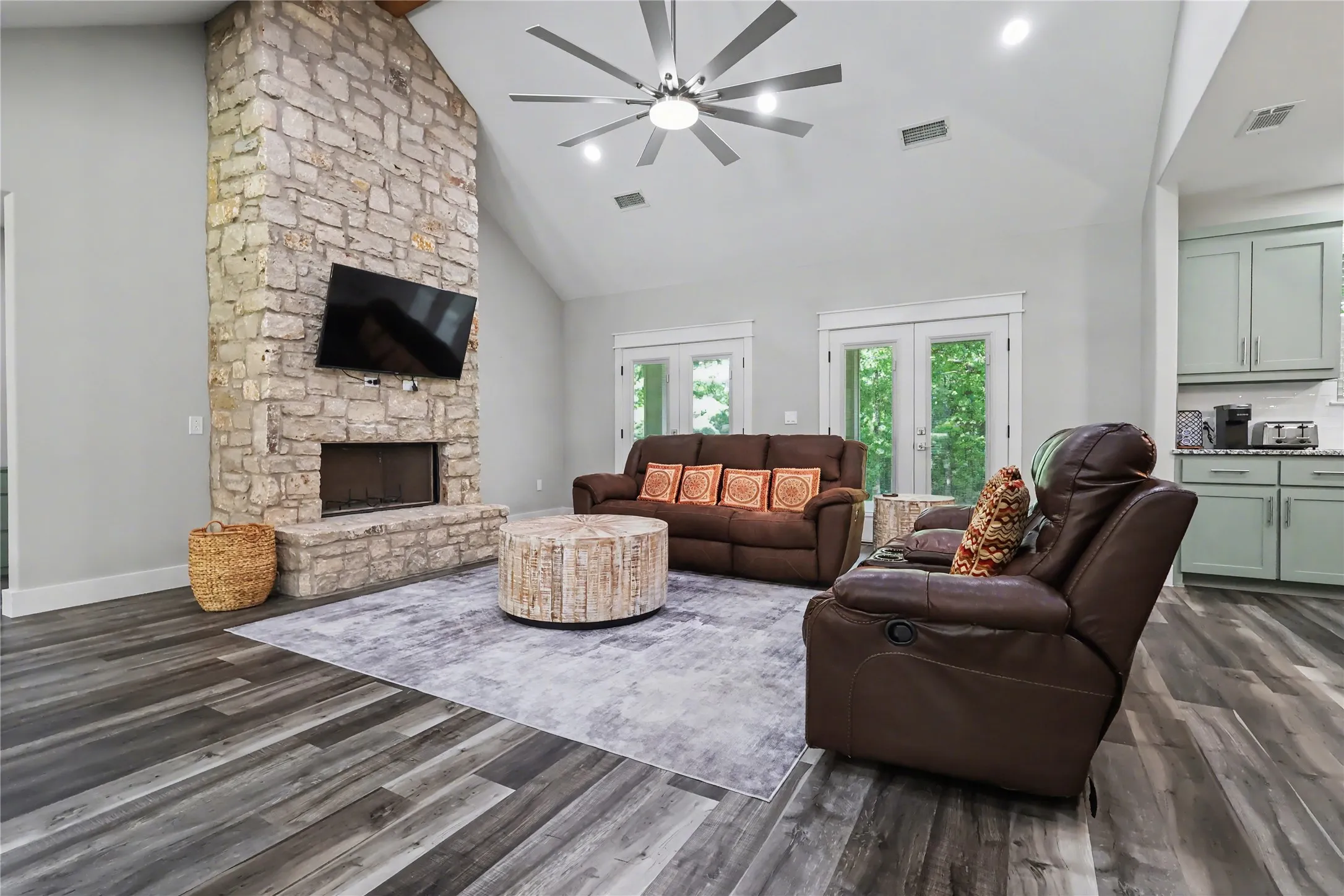 Living space featuring a stone-clad fireplace and wood-finish flooring