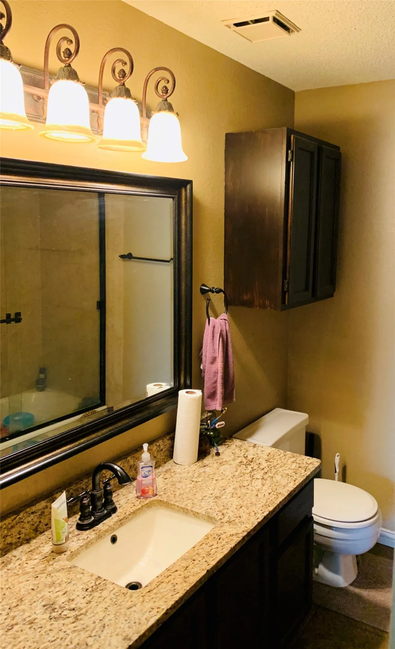 Vanity featuring a stone countertop, built-in sink, and bronze-finish faucet