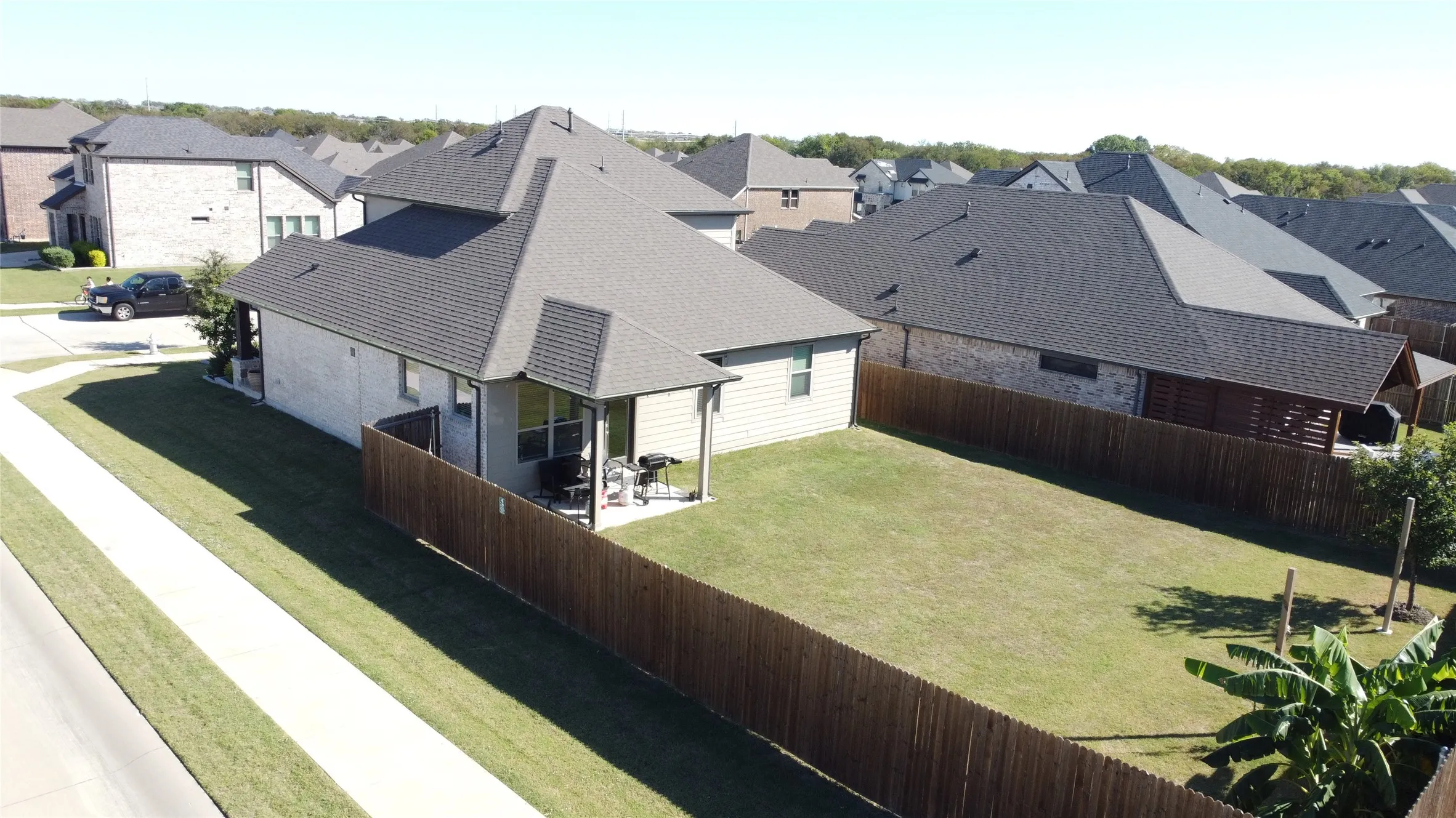 Fenced backyard featuring a manicured lawn and a covered patio area