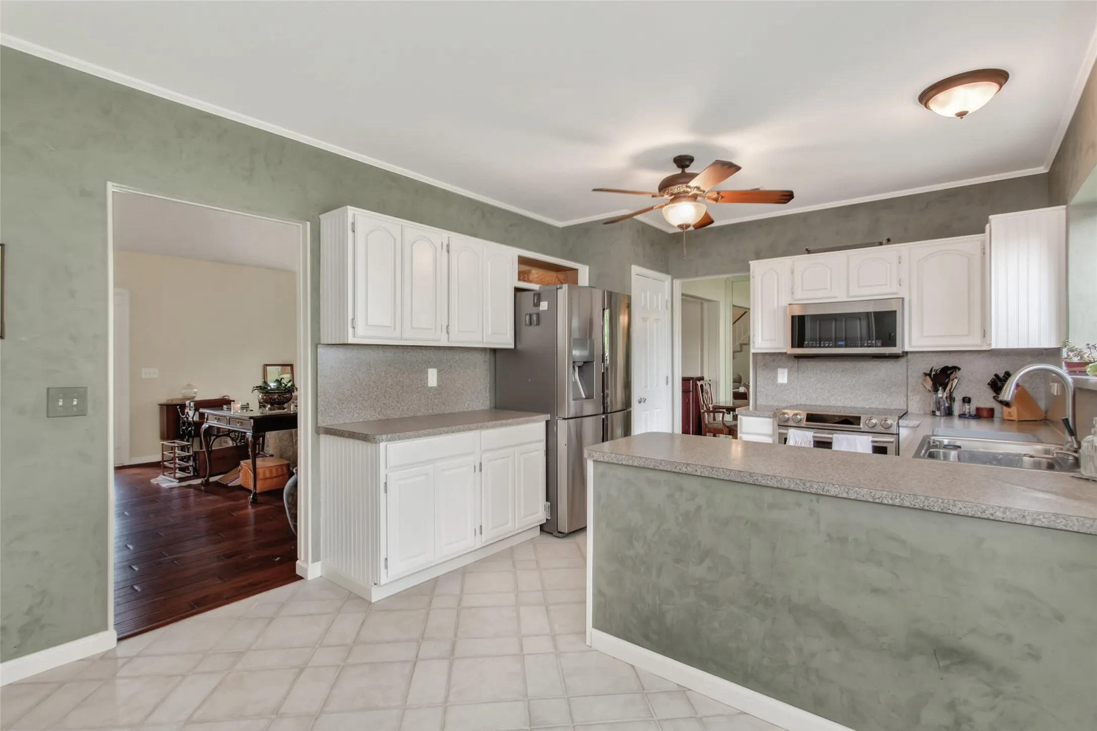 Kitchen featuring white cabinetry, stone-finish countertops, stainless steel appliances, and tile flooring