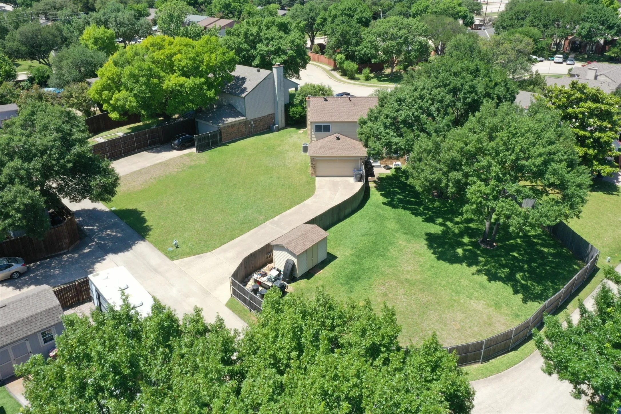 Expansive residential property with a detached storage shed, private driveway, and mature trees