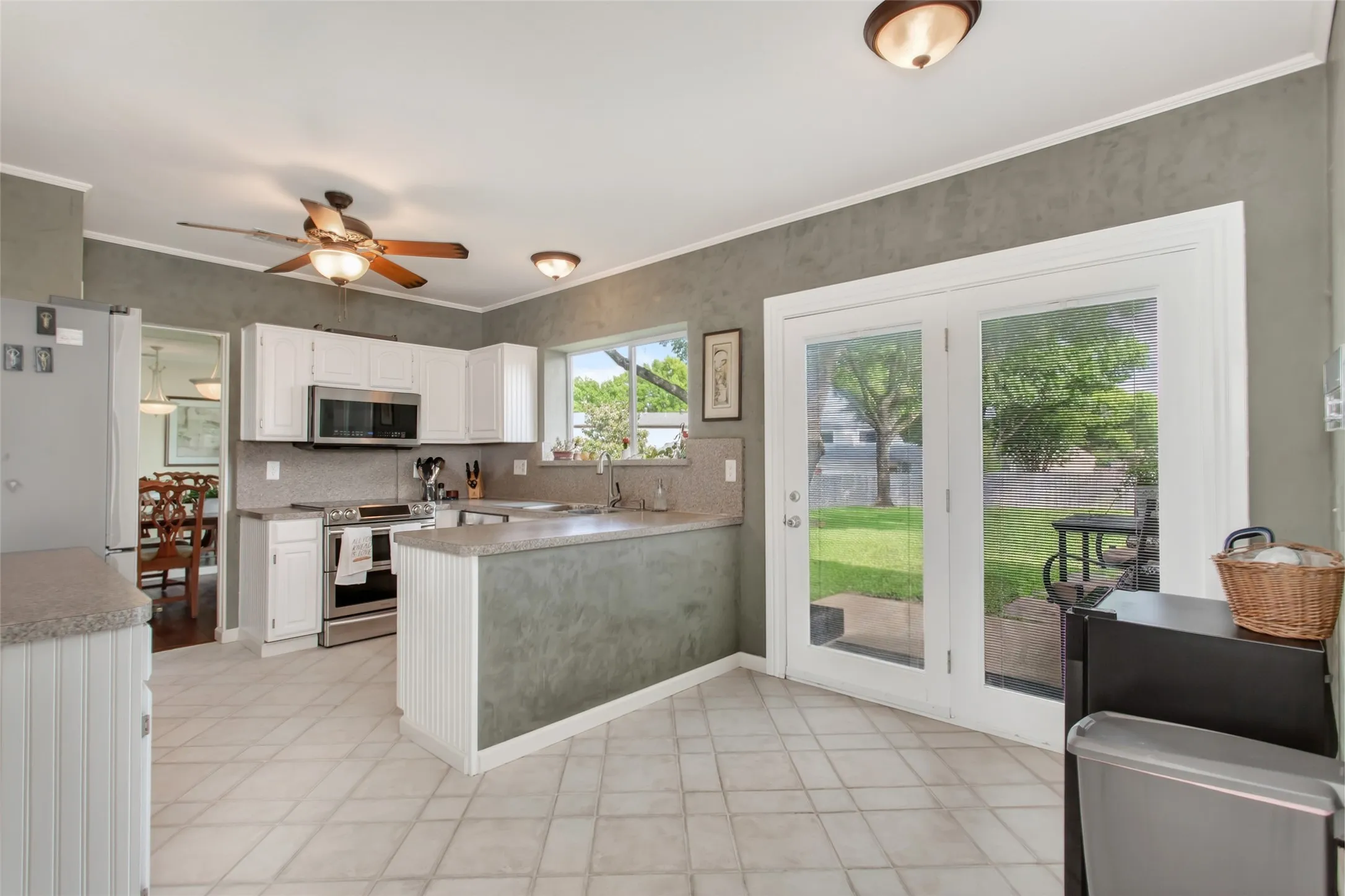 Kitchen featuring white cabinetry, stainless steel appliances, and tile flooring