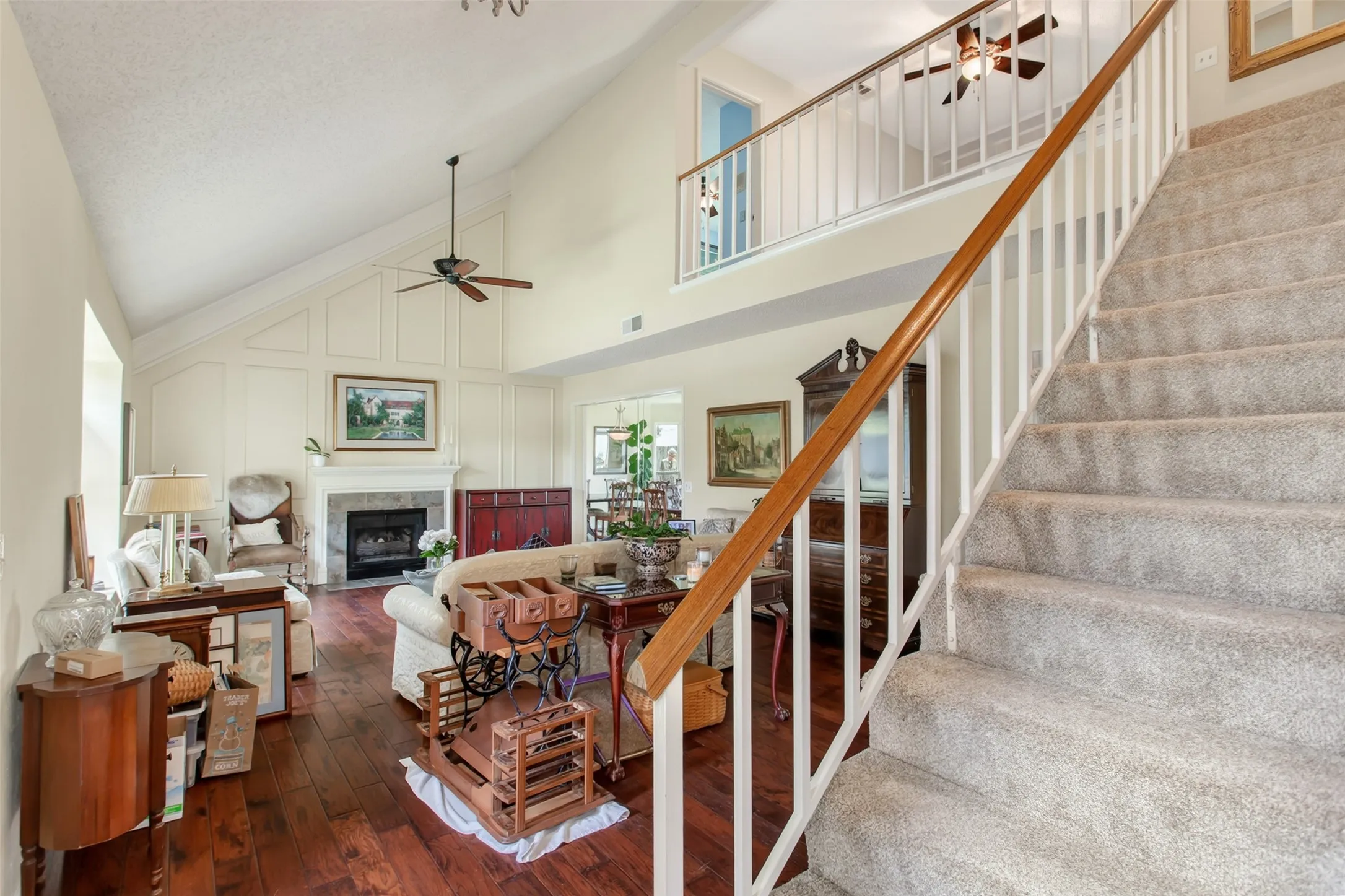 Carpeted staircase with wood-finish railing and white balusters