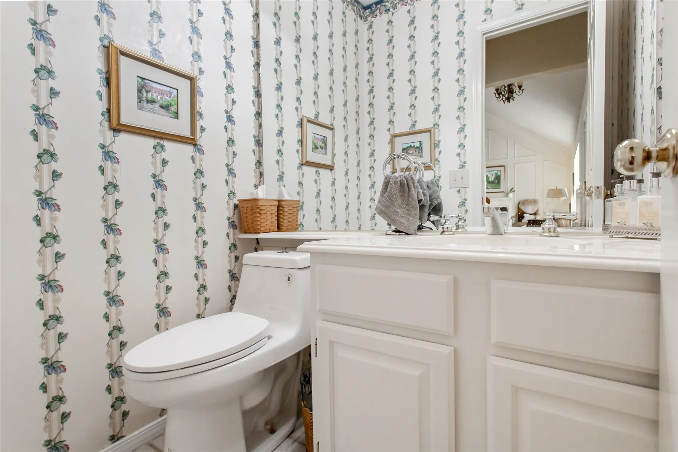 Bathroom vanity with a white countertop and integrated sink, complemented by a large wall mirror