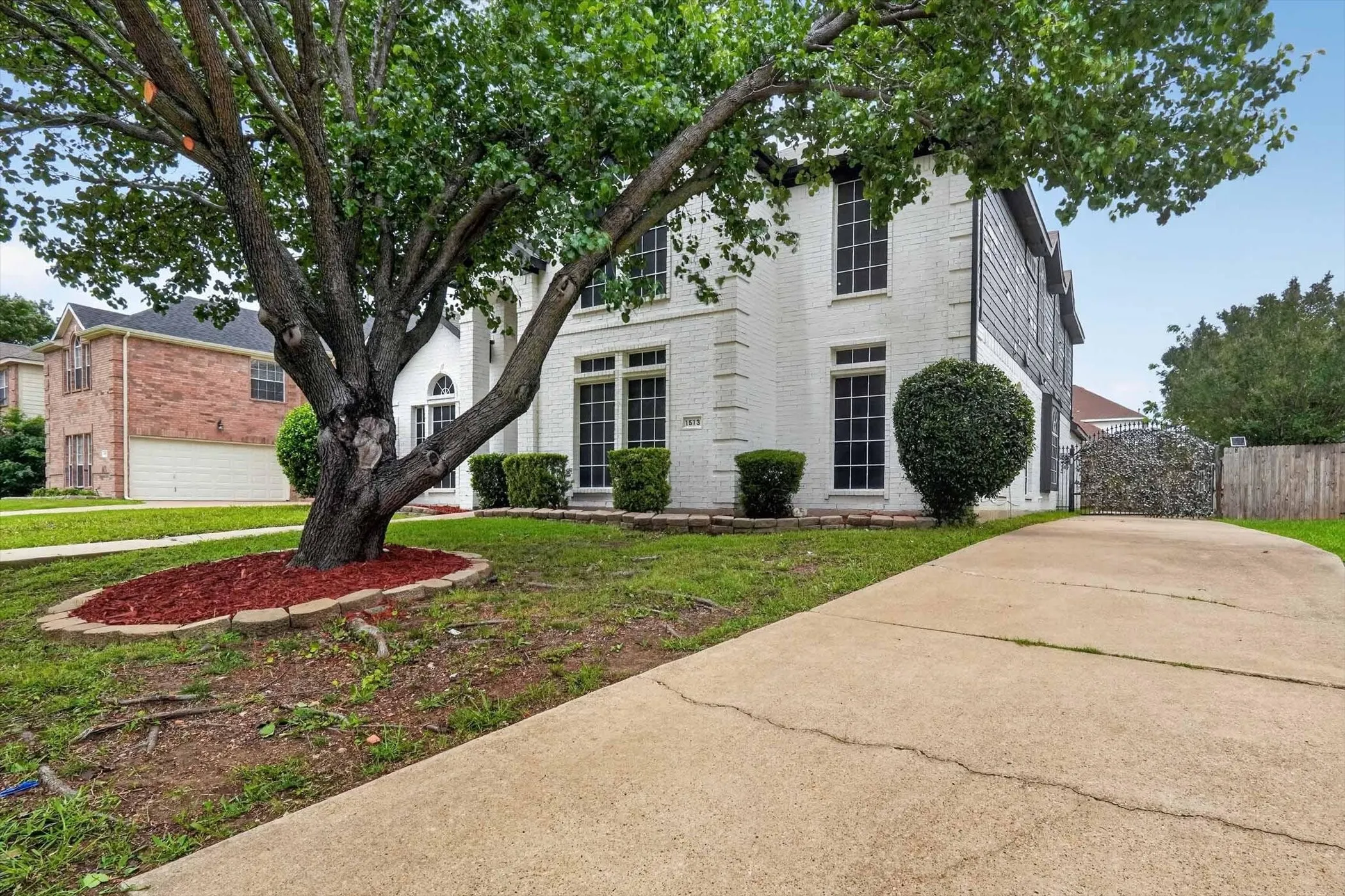 Two-story residence featuring a white brick facade and dark-framed windows