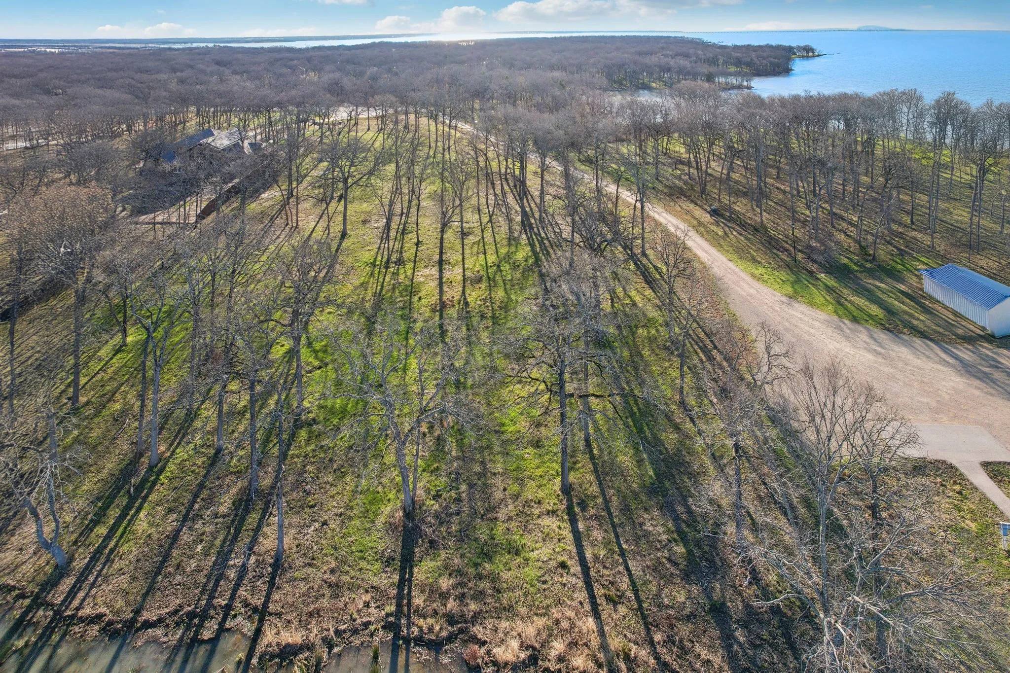 Birds eye view of property with a forest view and a water view