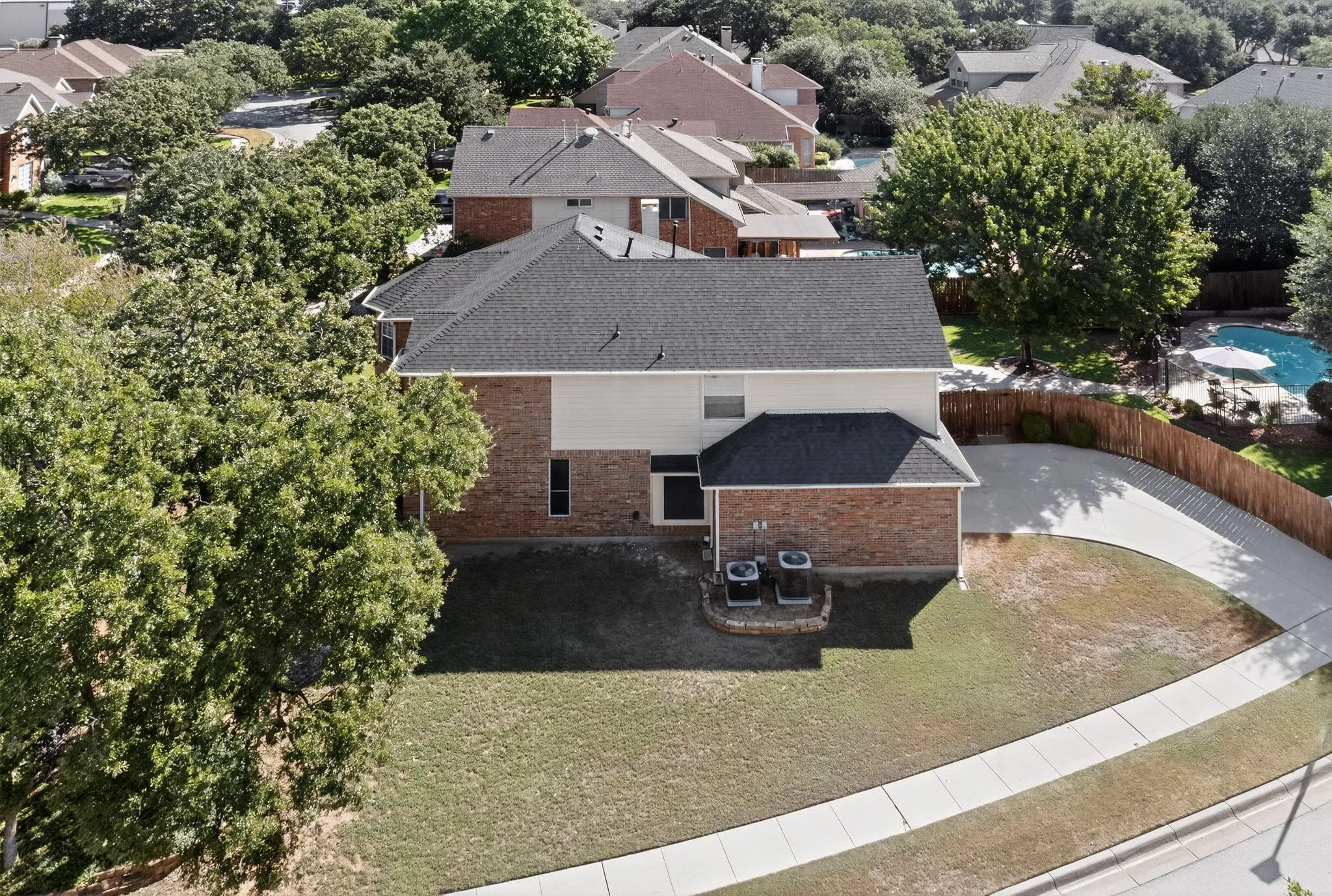 Two-story residence featuring a brick and siding exterior and a dark shingle roof
