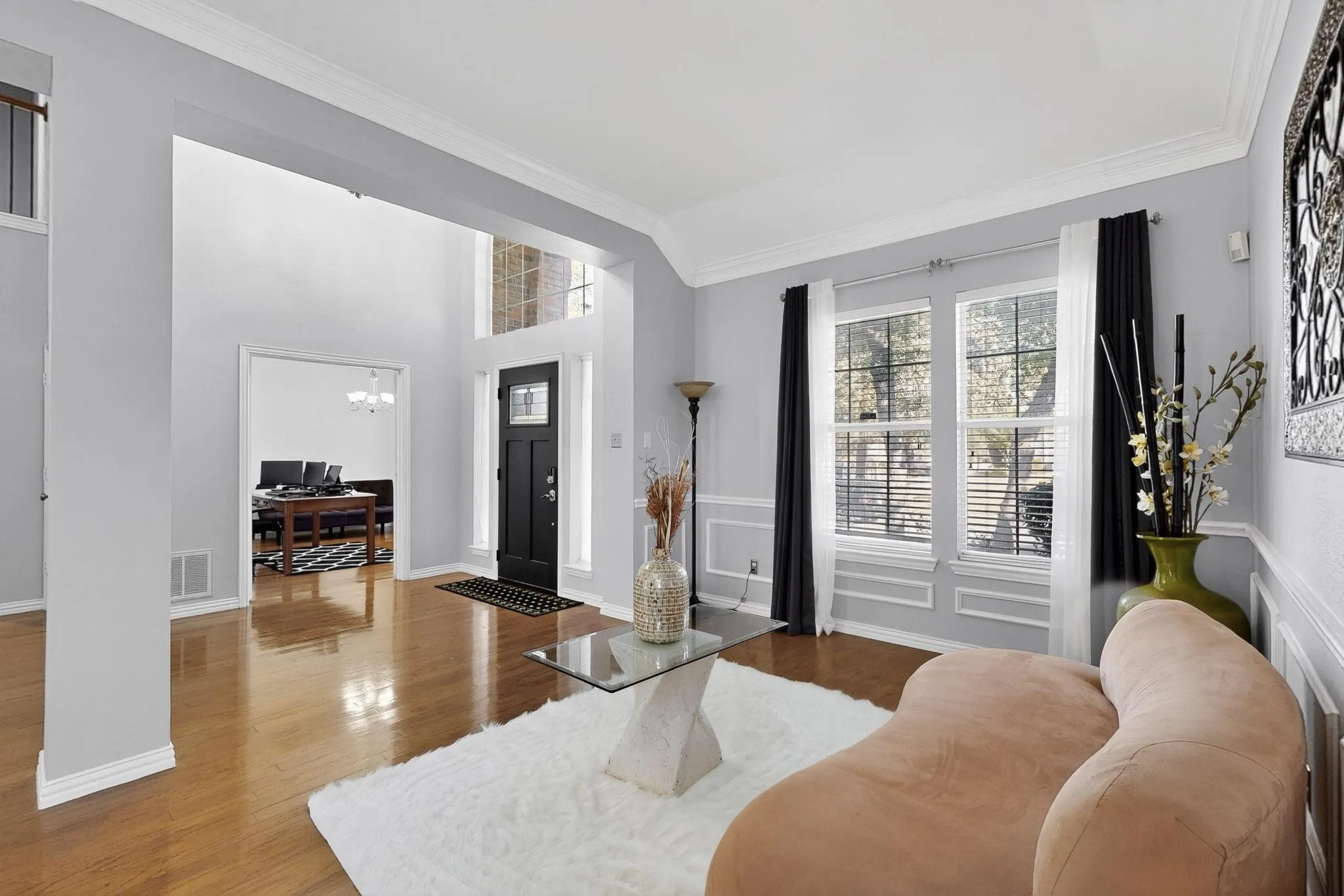 Foyer featuring wood-finish flooring, a black front door with decorative glass, and a transom window