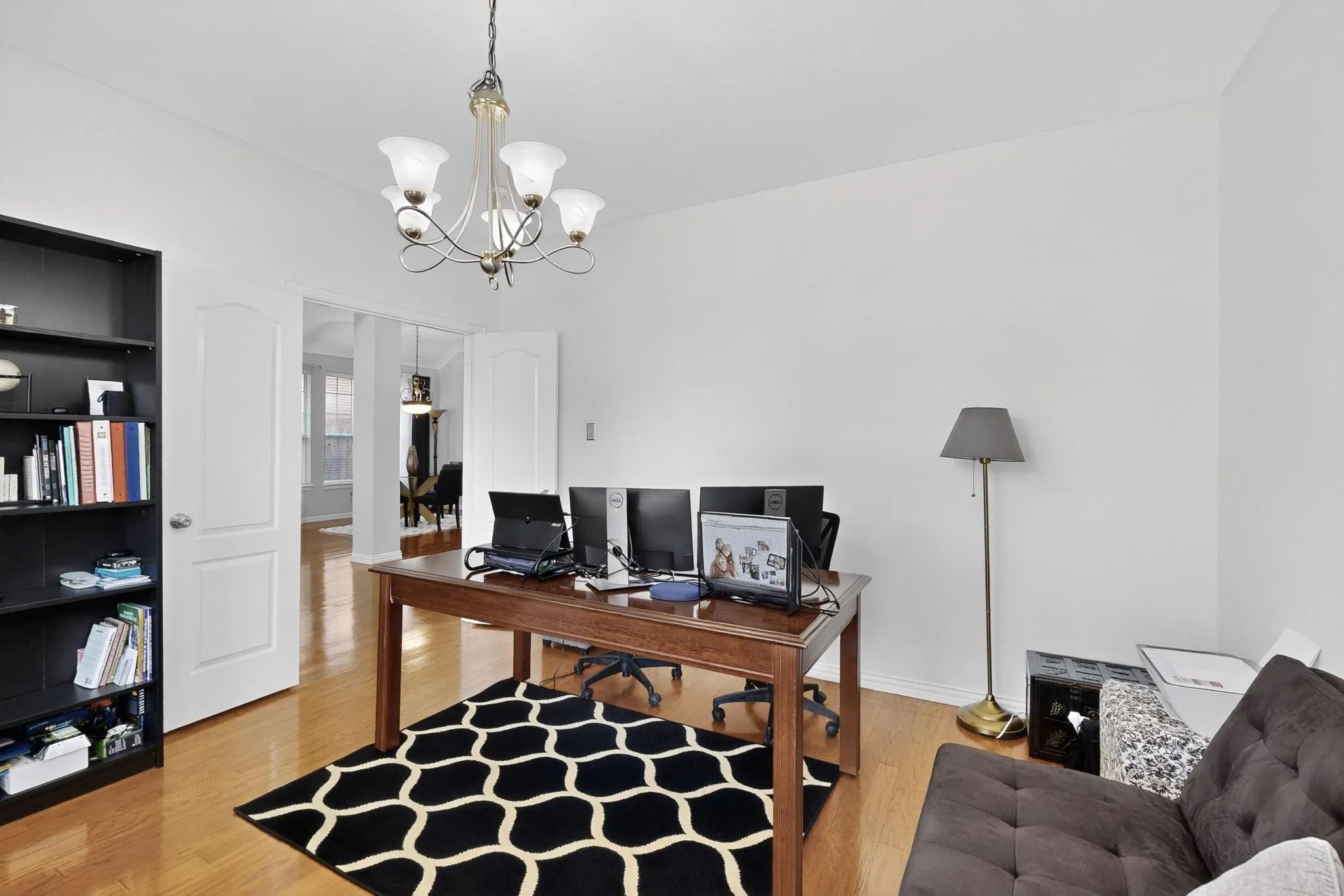 Spacious room featuring wood-finish flooring and a decorative chandelier