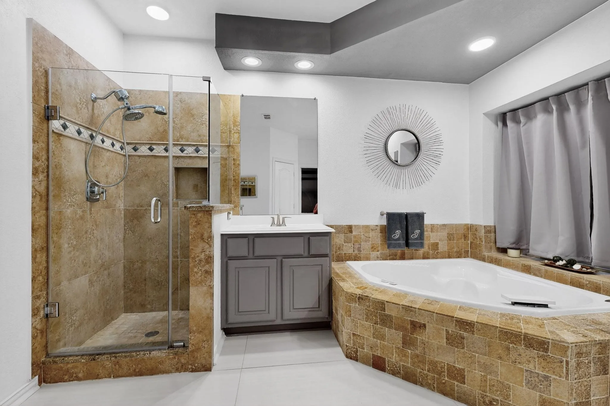Bathroom featuring a glass-enclosed shower with custom tile work, a built-in soaking tub, a single vanity with storage, recessed lighting, and light-tone flooring