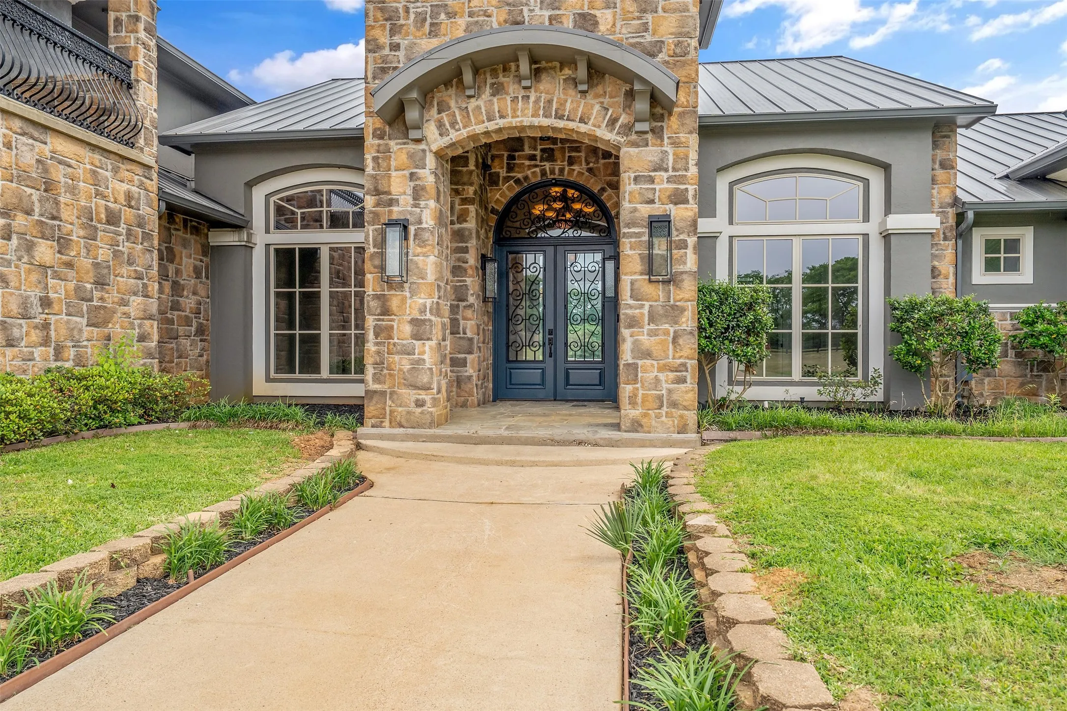 Stone and stucco exterior with a metal roof