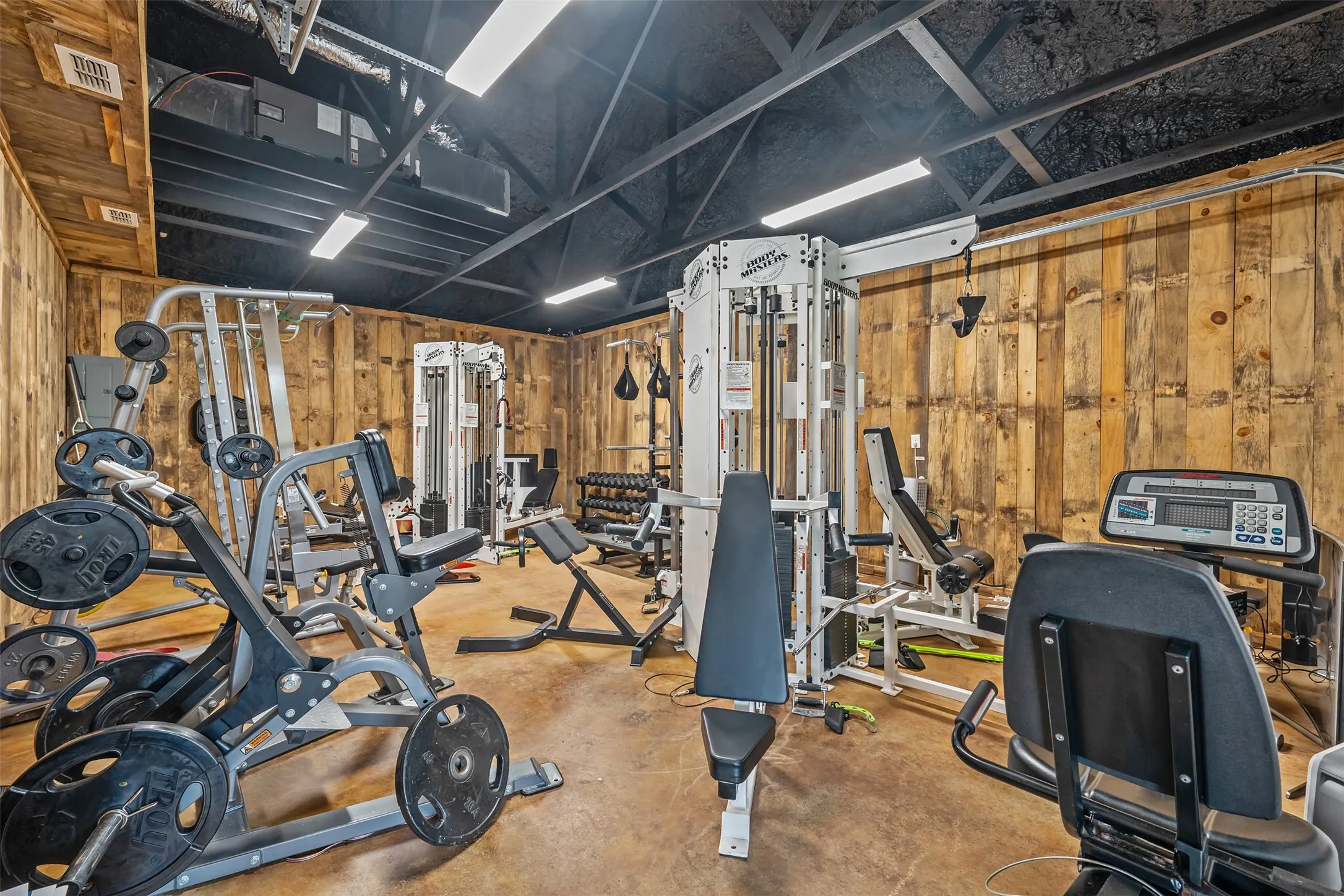 Dedicated fitness space featuring wood paneling