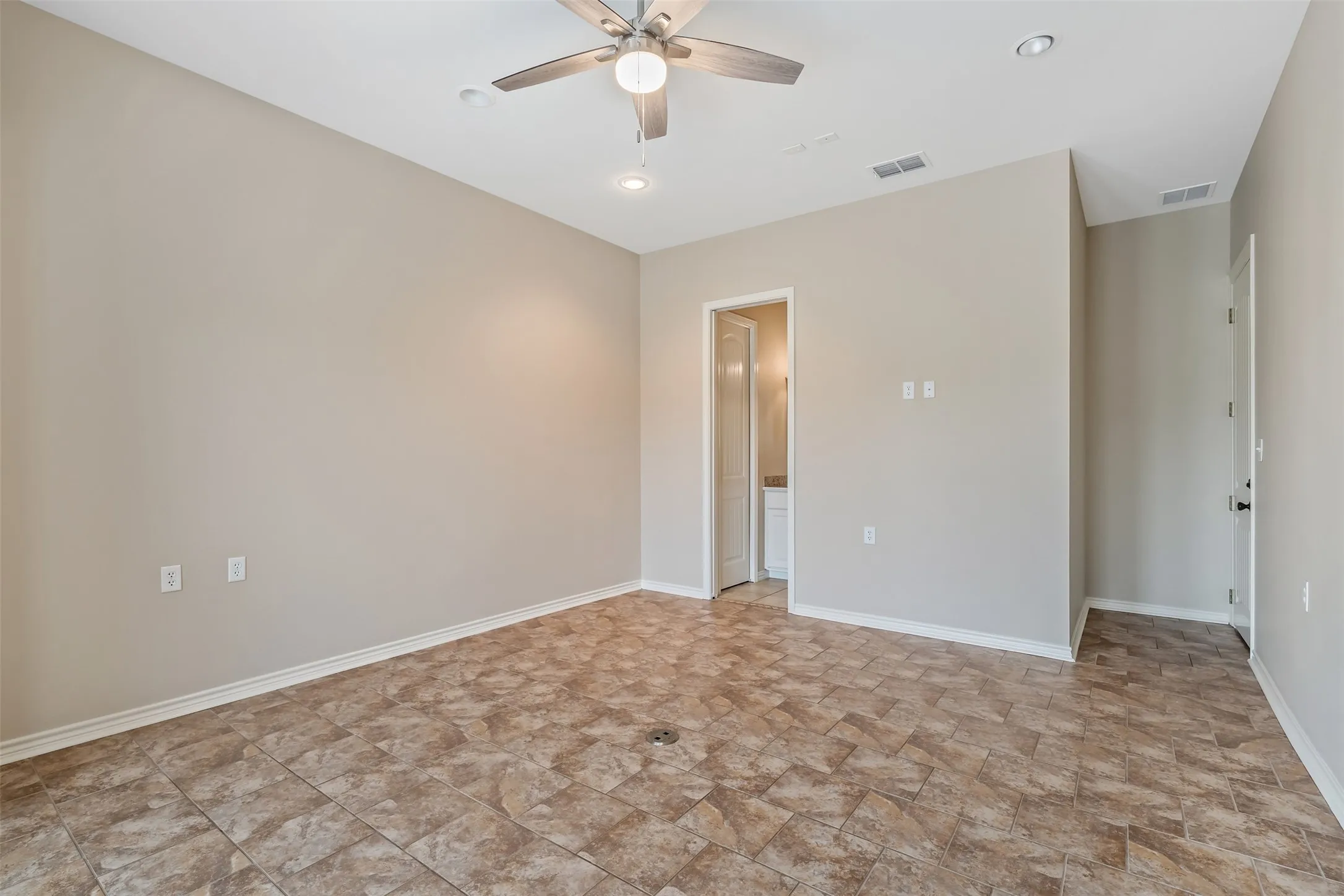 Spacious room featuring neutral tone walls, tile flooring, a ceiling fan, recessed lighting, and white trim