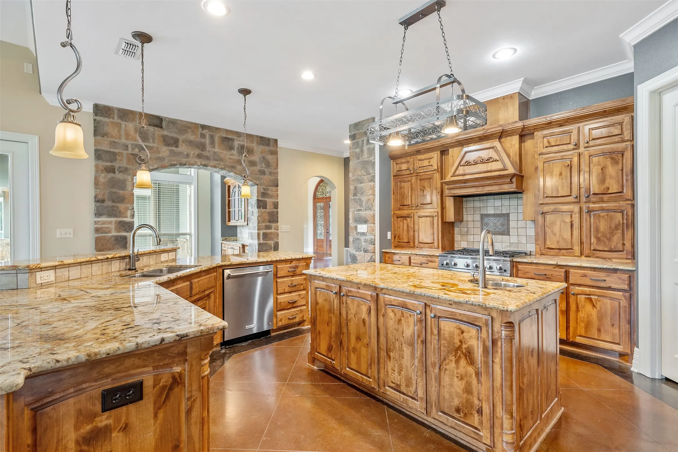 Kitchen featuring custom wood cabinetry, granite countertops, and stainless steel appliances