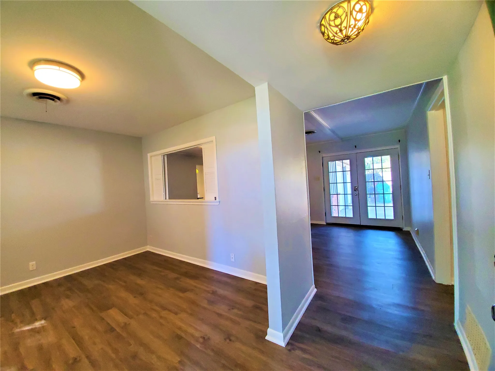 Entry open to formal living room with shuttered access to family room
