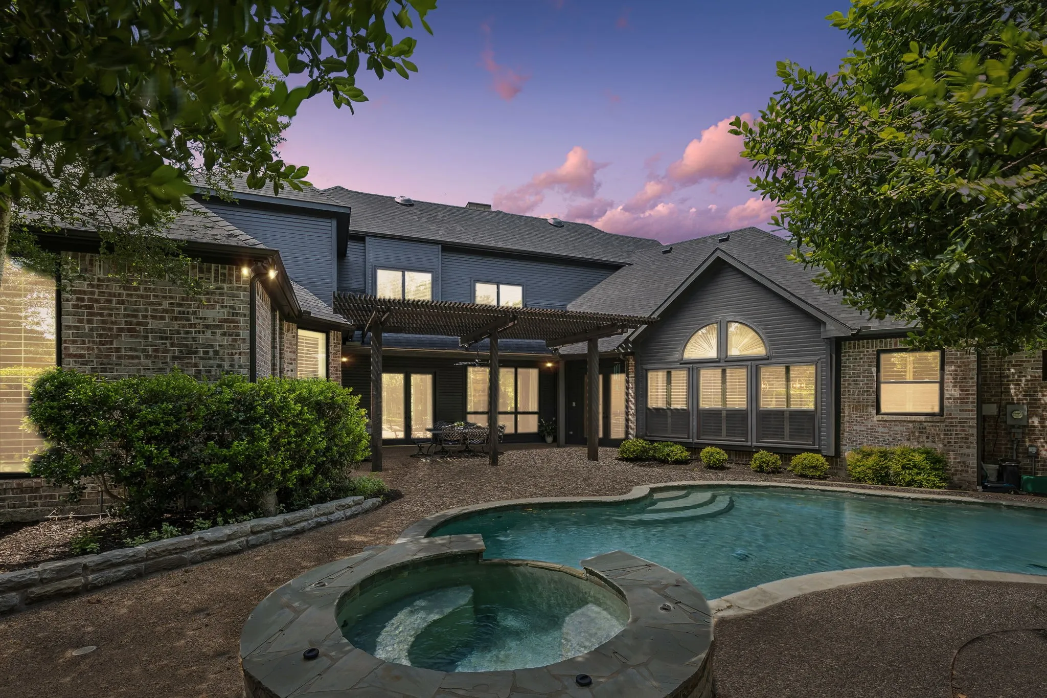 Backyard retreat with pool, patio, and multiple areas to relax or entertain surrounded by mature trees for complete privacy.