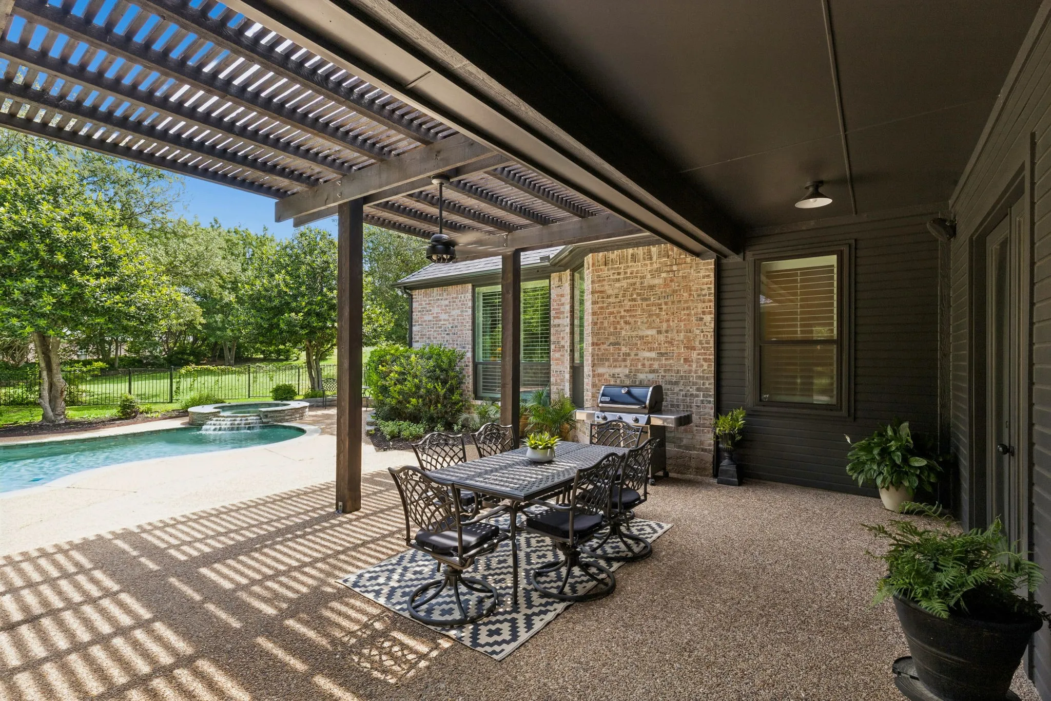 Backyard retreat with pool, patio, and multiple areas to relax or entertain surrounded by mature trees for complete privacy.