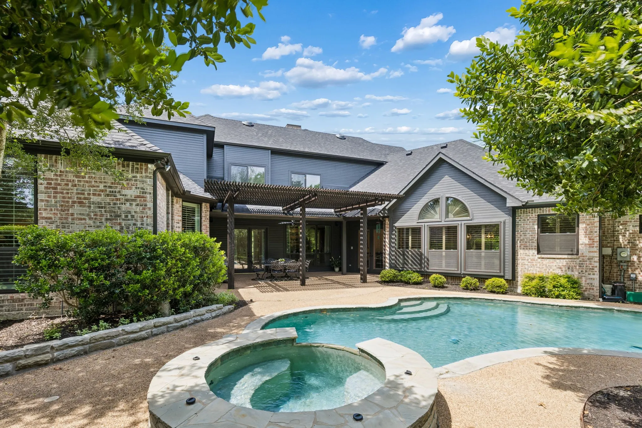 Backyard retreat with pool, patio, and multiple areas to relax or entertain surrounded by mature trees for complete privacy.