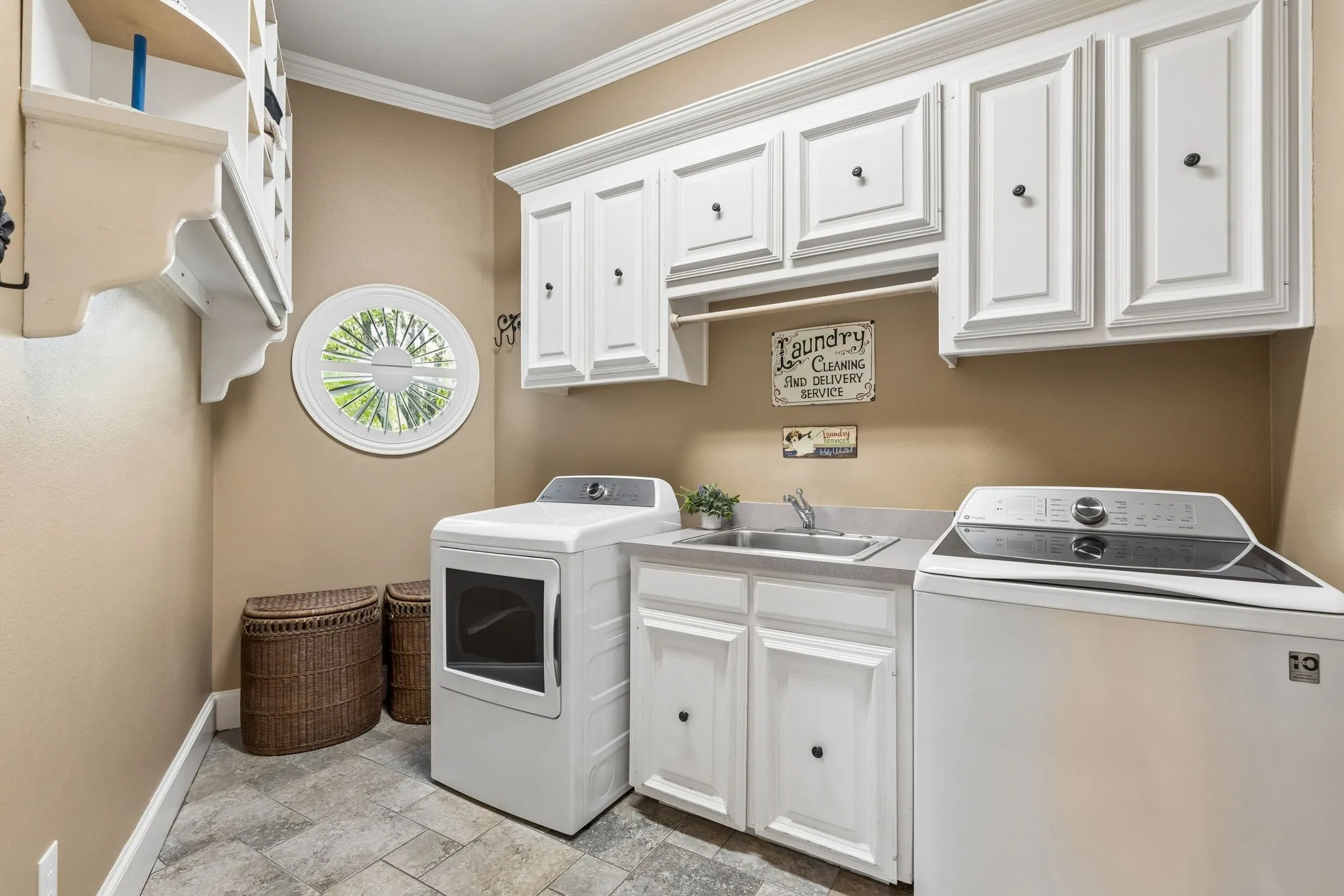 Huge laudry room with hanging rack, sink and lots of cabinetry.
