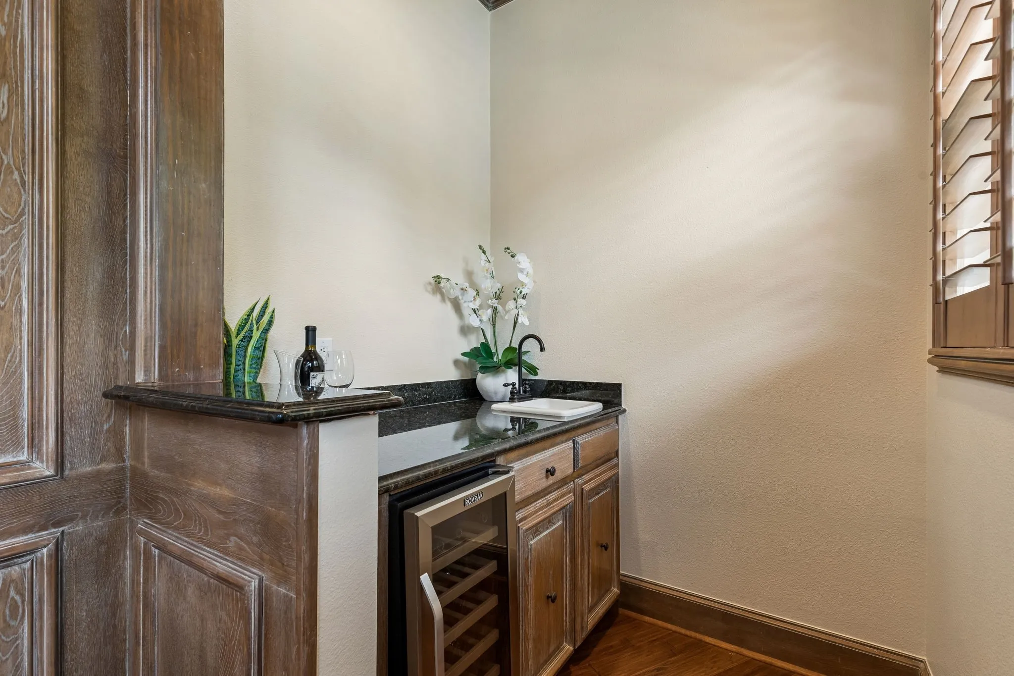 Wet bar with wine fridge easily accessible from family room and outdoor entertainment.