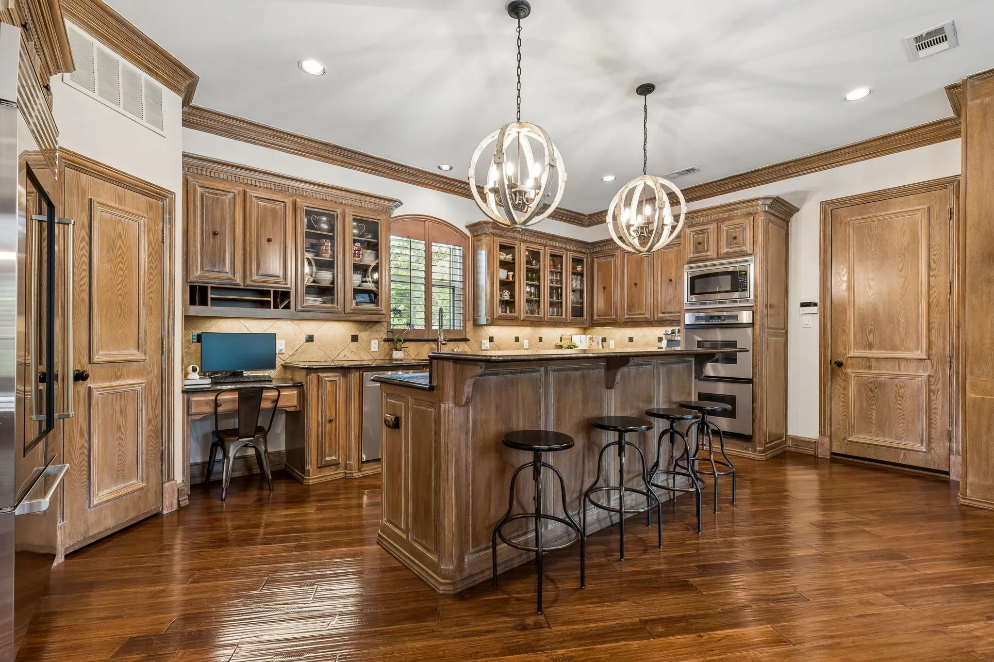Convenient breakfast bar and custom island lighting by Paul Michael.