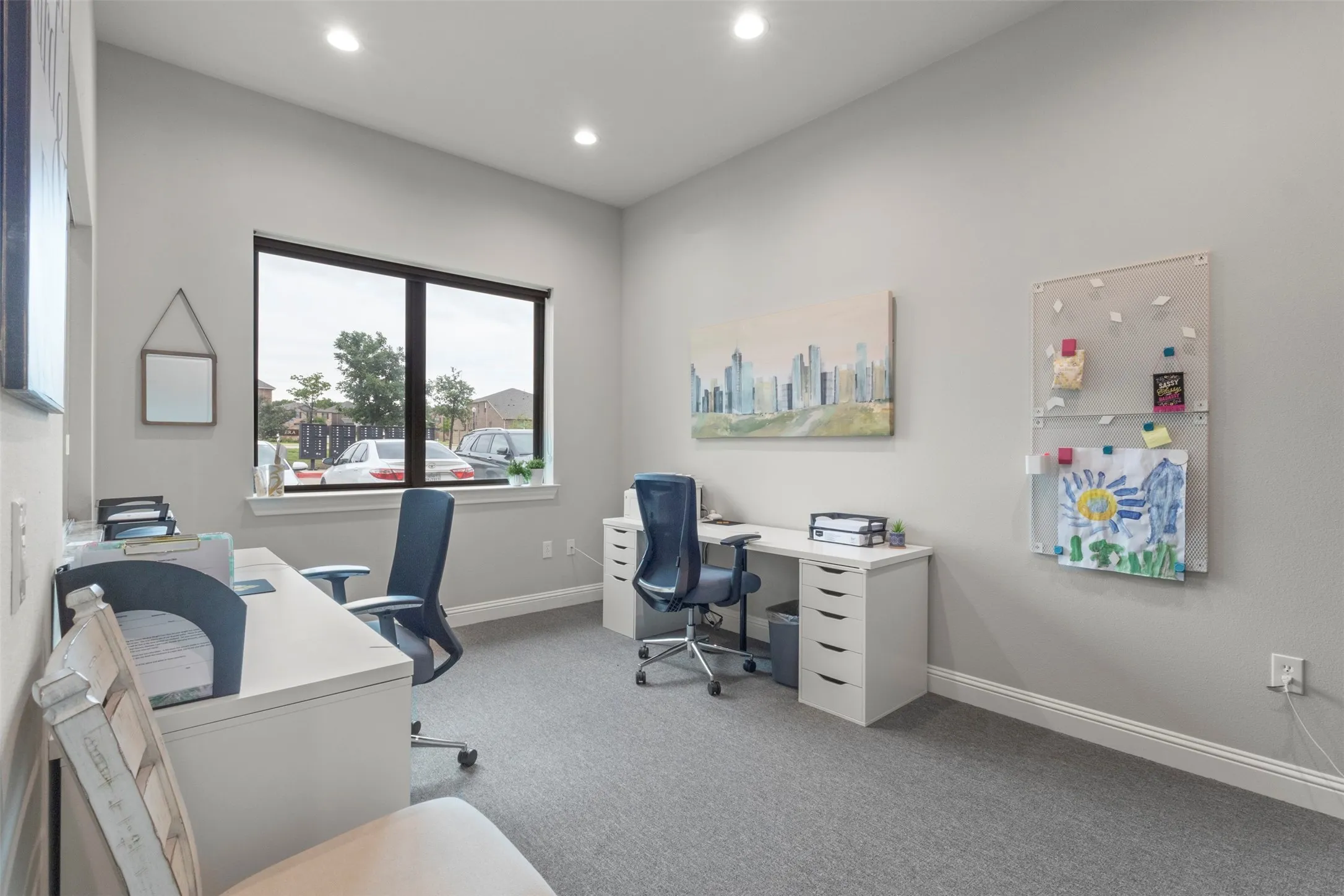Expansive room featuring light gray walls, recessed lighting, a large window with dark trim, light gray carpeting, and white baseboards