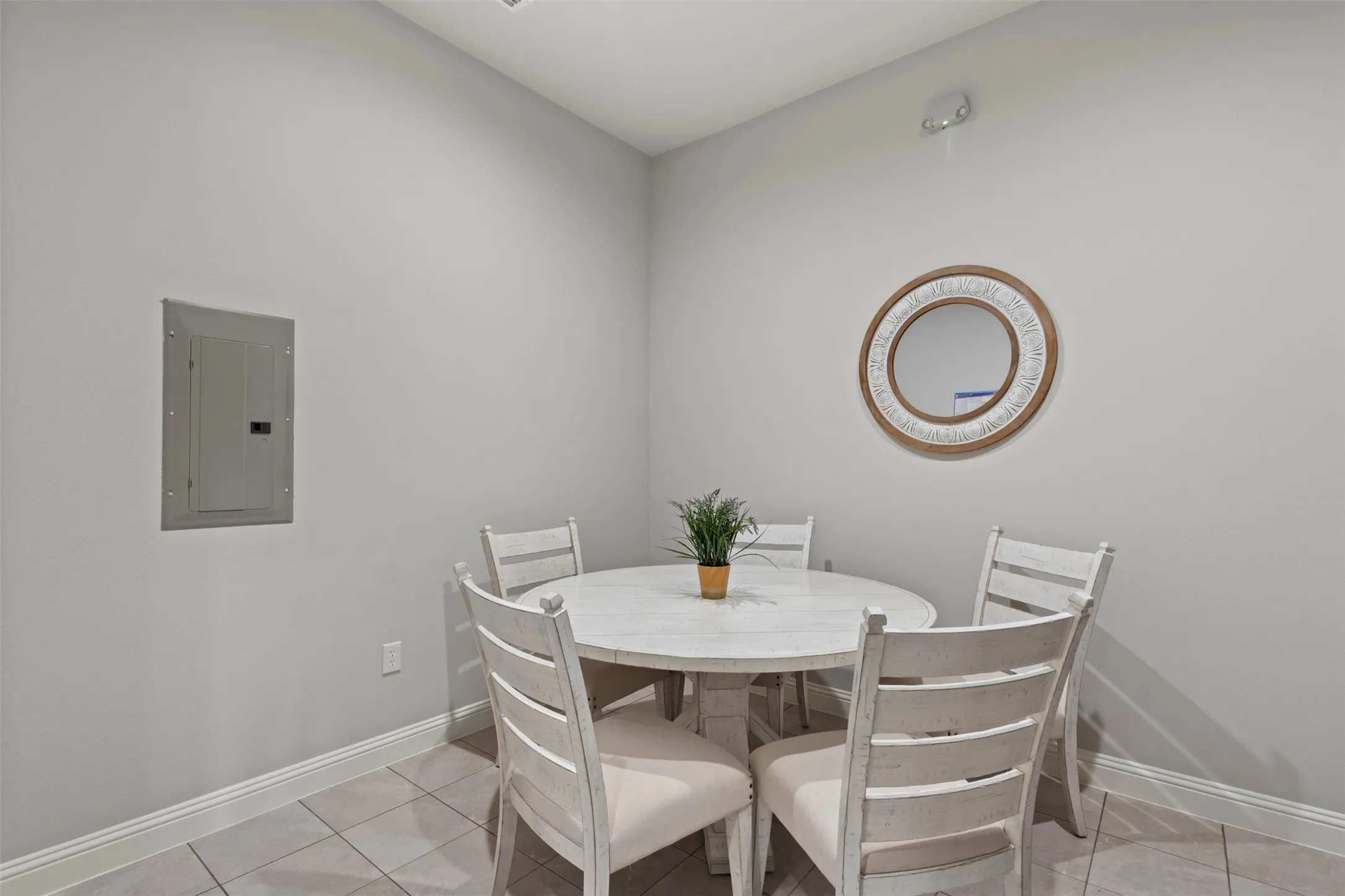 Recessed dining area featuring light gray wall paint, tile flooring, and white baseboards