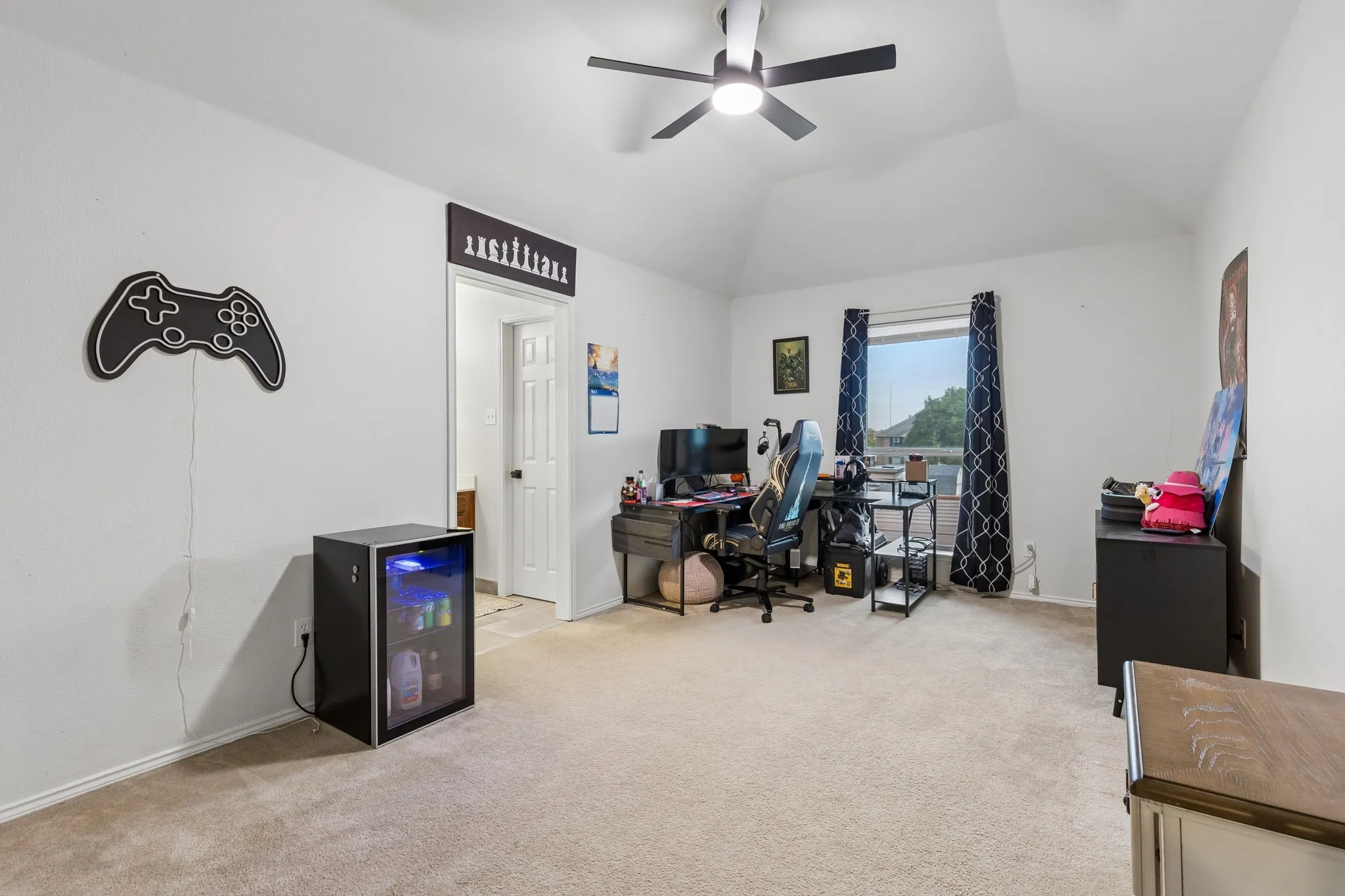 Spacious room being used as office, featuring vaulted ceilings
