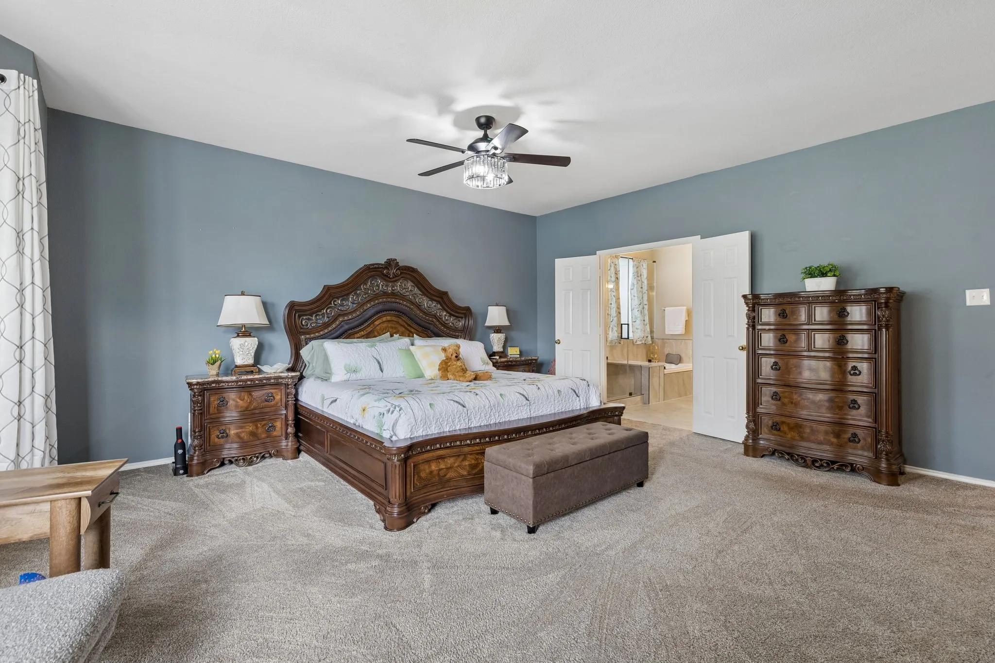 Spacious primary bedroom with double-door entry to an en-suite bathroom