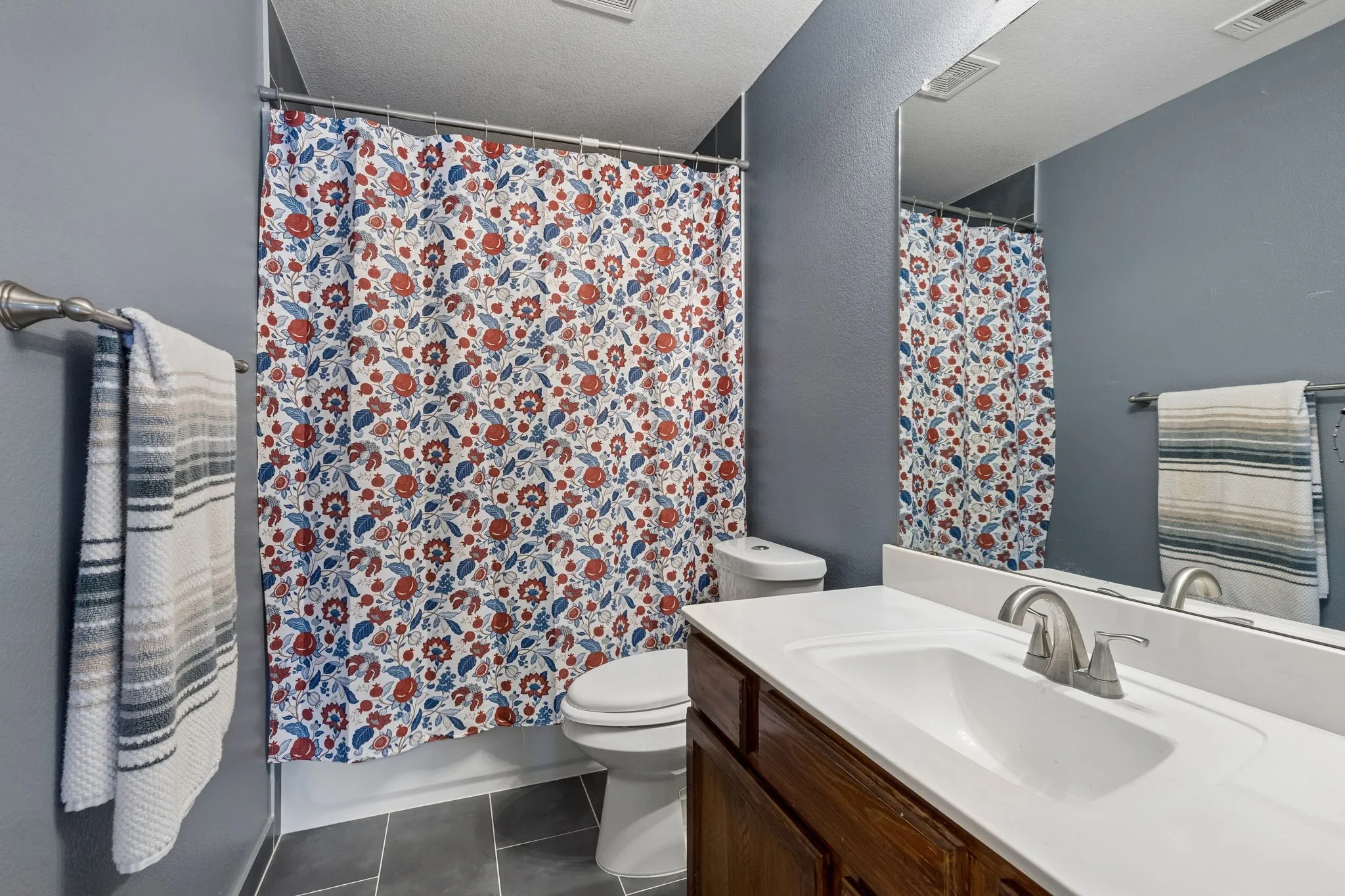 Updated bathroom featuring a vanity with a white countertop and undermount sink, brushed nickel faucet