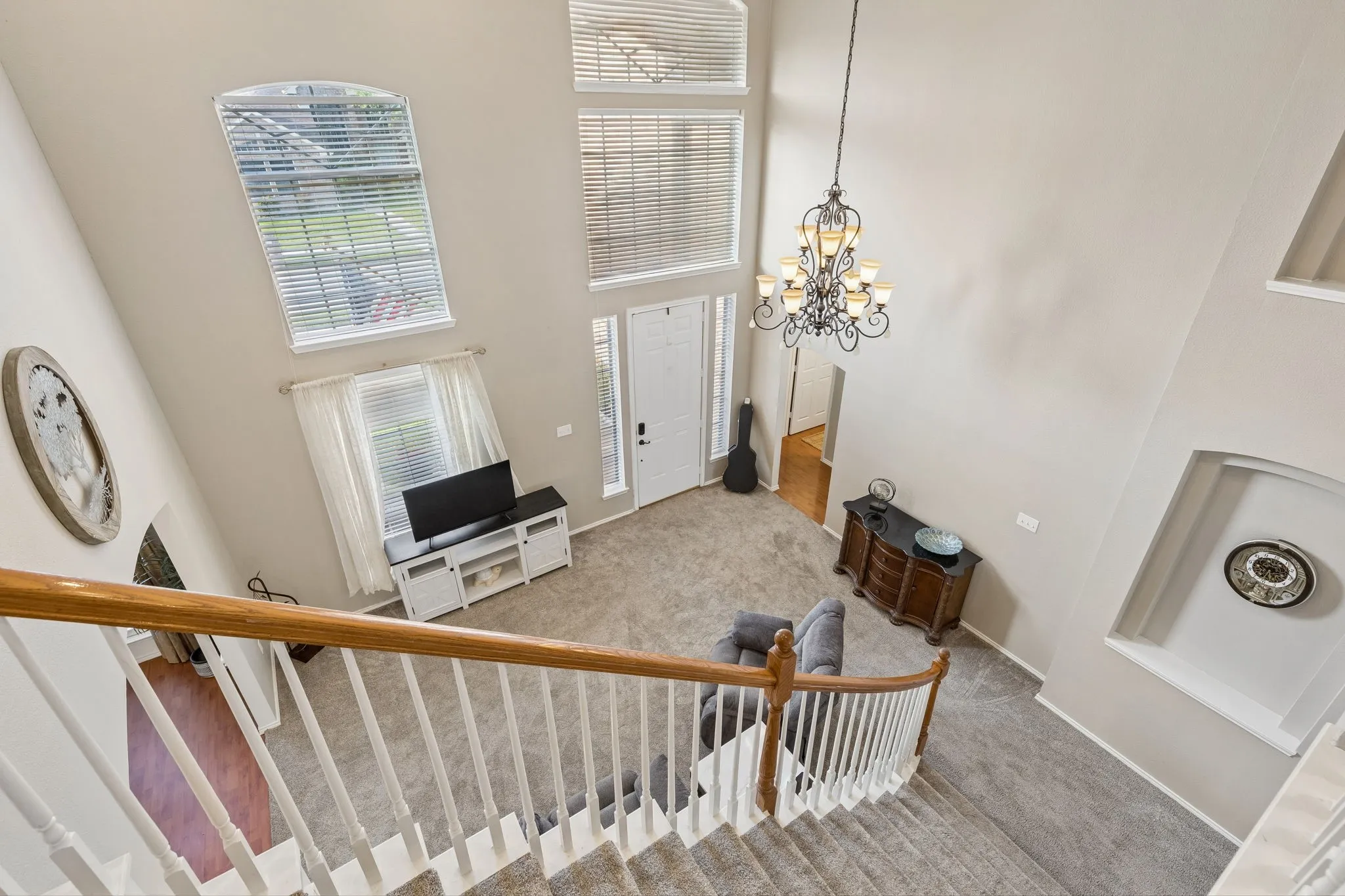 Two-story foyer featuring a chandelier, arched window, and transom windows