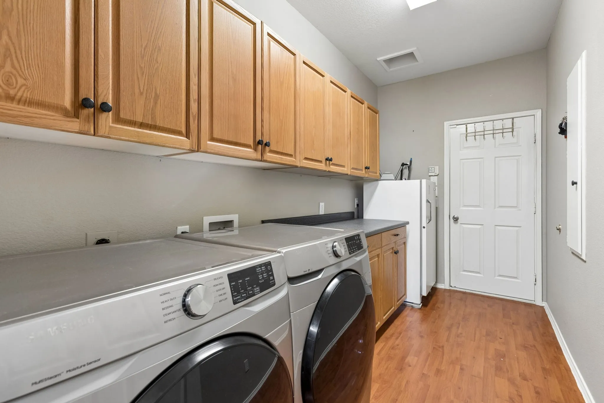 Large laundry room ample storage, featuring laundry shute from upstairs.